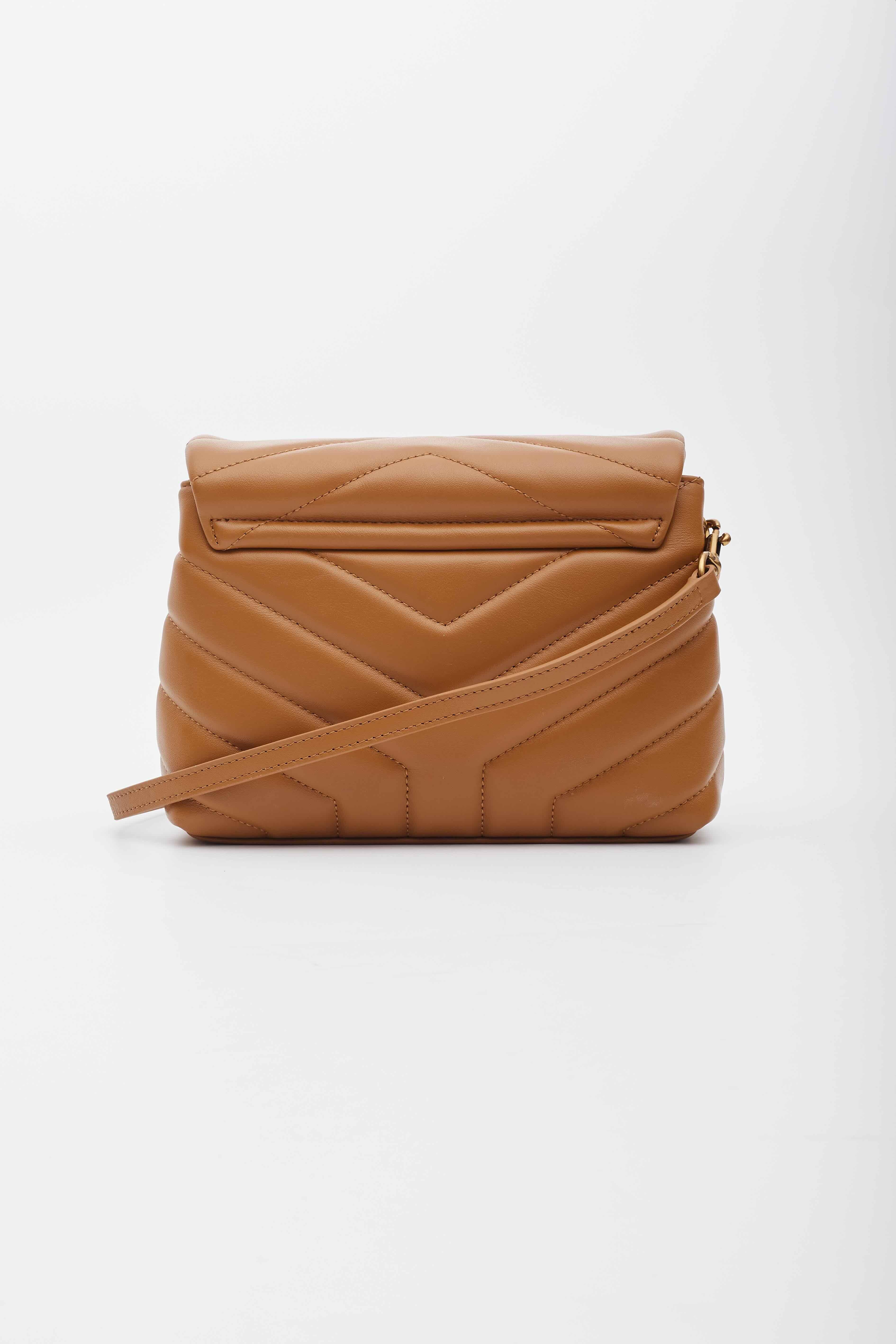 This shoulder bag is made of smooth calfskin leather in dark tan. The bag features signature Y quilting, the brand monogram at front, a  crossbody strap, aged gold hardware, a front flap and an interior of black fabric with multi compartments and a