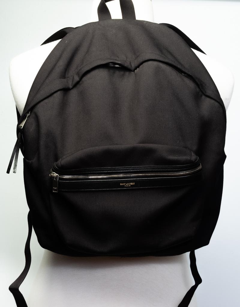 This durable backpack is made from black canvas with leather trim and leather details. The bag features padded nylon shoulder straps, a top handle and an exterior zipper pocket at front with an attached leather strap key holder.

COLOR: