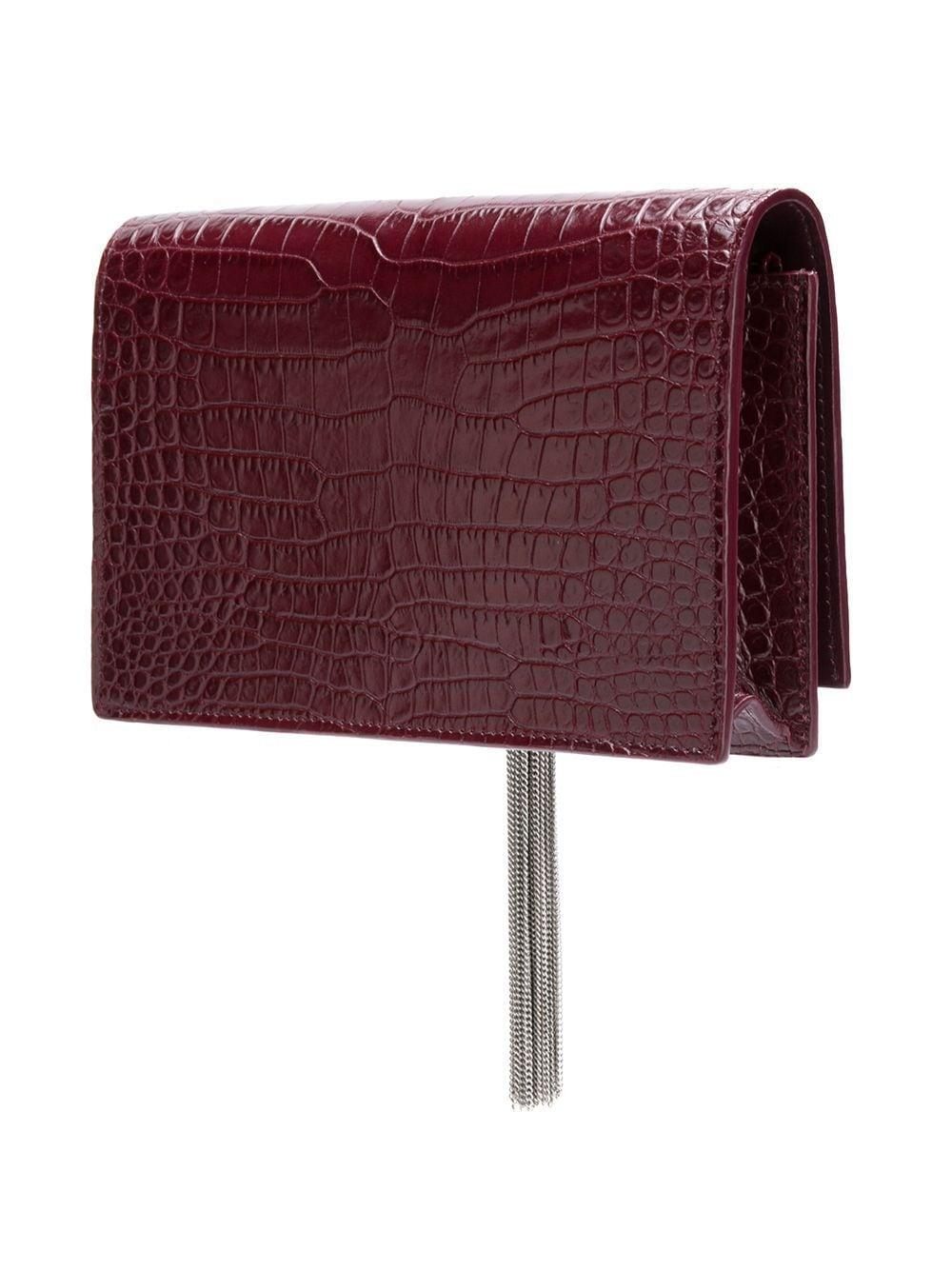 This classic Saint Laurent shoulder bag is made with burgundy red croc embossed calf leather with a long gourmette (a jewellery chain) strap in sliver tone. The bag features sliver tone hardware, a front foldover flap, a signature YSL monogram logo