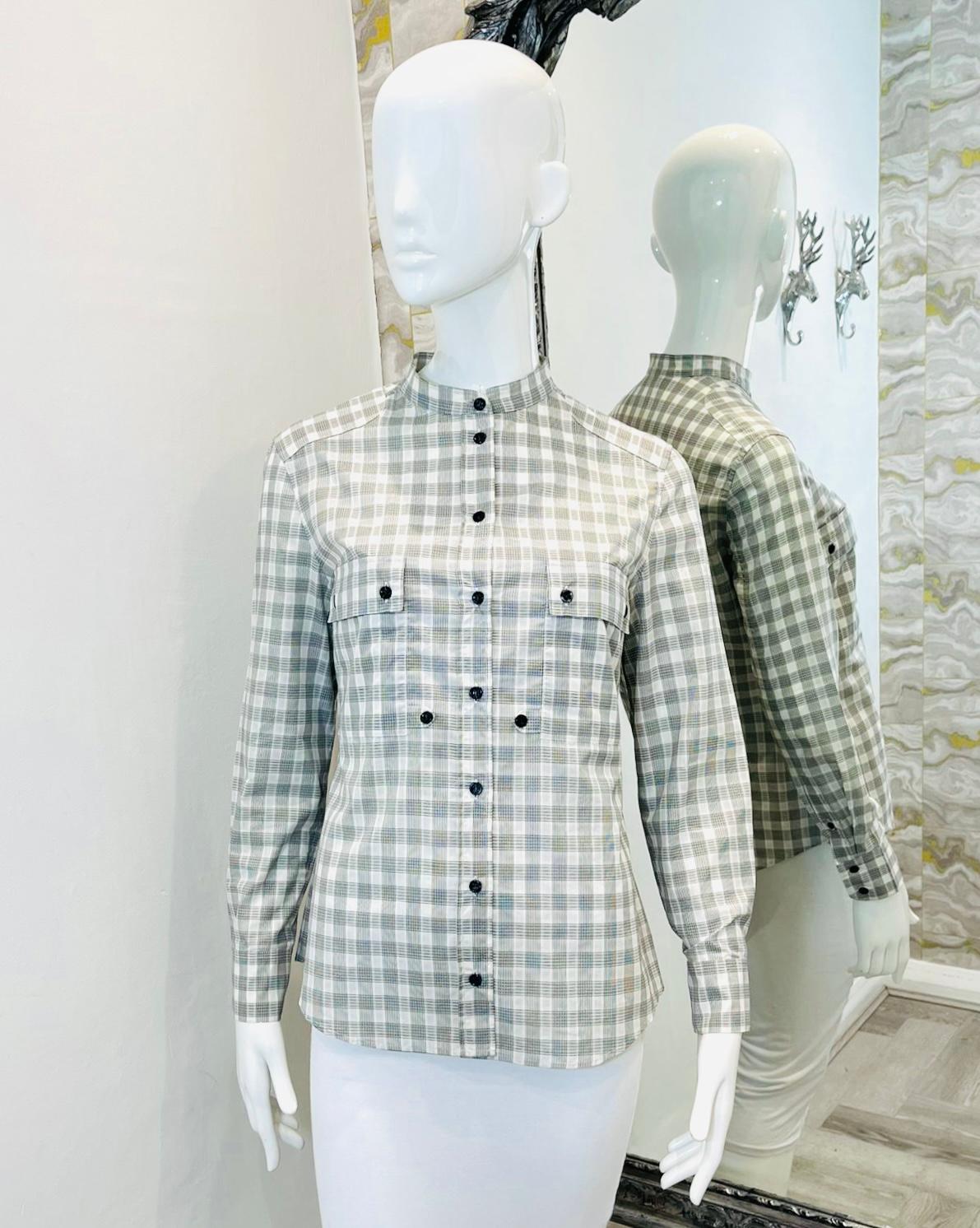 Saint Laurent Checked Cotton Shirt

Light grey, long sleeved shirt designed with check pattern.

Featuring a standing collar and black button closure.

Detailed with flap chest pockets and buttoned cuffs.

Size – 40FR

Condition – Very