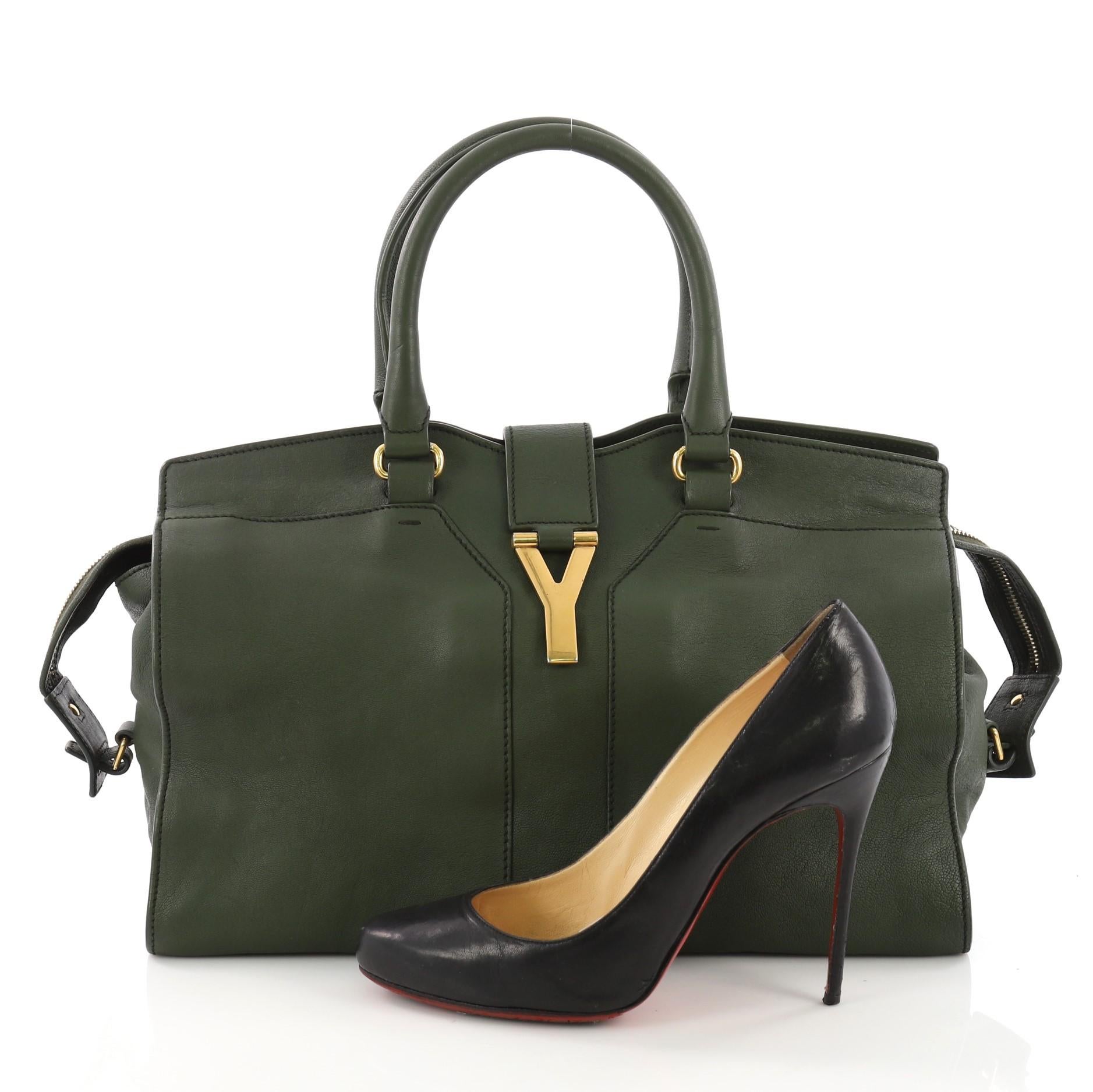This Saint Laurent Chyc Cabas Tote Leather Medium, crafted from green leather, features signature 'Y' top flap hardware piece, dual rolled handles, protective base studs, and gold-tone hardware. Its two-way zip closure opens to a black fabric