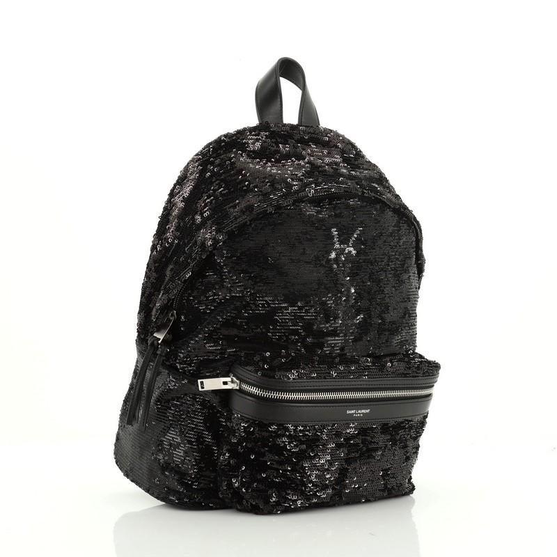 This Saint Laurent City Backpack Sequins Mini, crafted from black sequins, features adjustable padded straps, exterior front zip pocket, and silver-tone hardware. Its two-way zip closure opens to a black fabric interior with zip pocket. 

Estimated