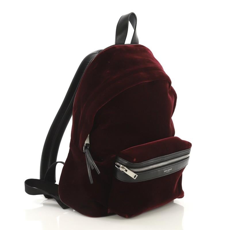 This Saint Laurent City Backpack Velvet Mini, crafted from red velvet, features, adjustable padded strap, exterior front zip pocket and matte silver-tone hardware. Its two-way zip closure opens to a black fabric interior with zip pocket. 

Estimated
