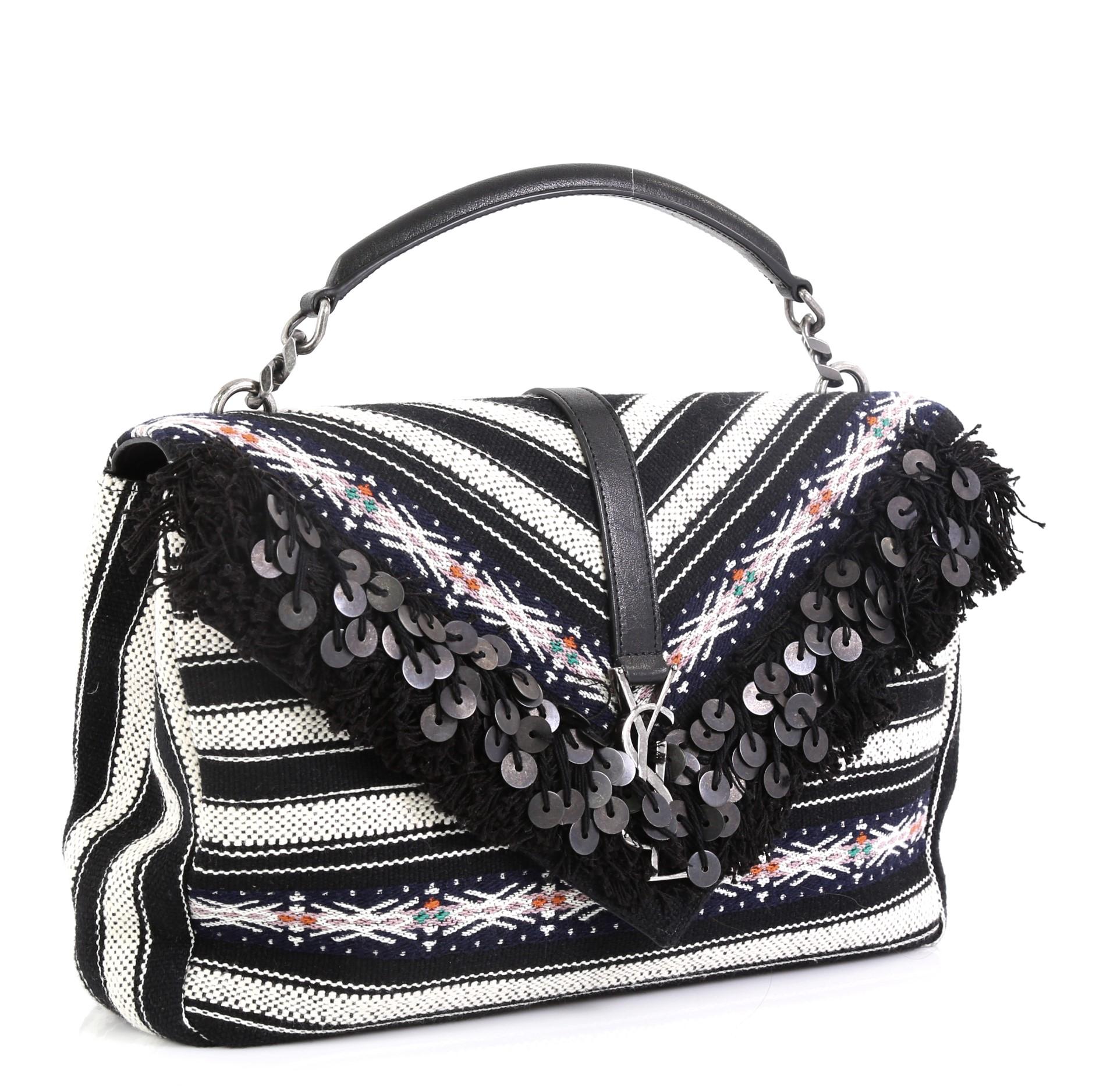 This Saint Laurent Classic Monogram College Bag Fringe Canvas with Sequins Large, crafted in black canvas, features a single top handle, fringe and sequins detailing and silver-tone hardware. Its magnetic snap closure opens to a black leather and