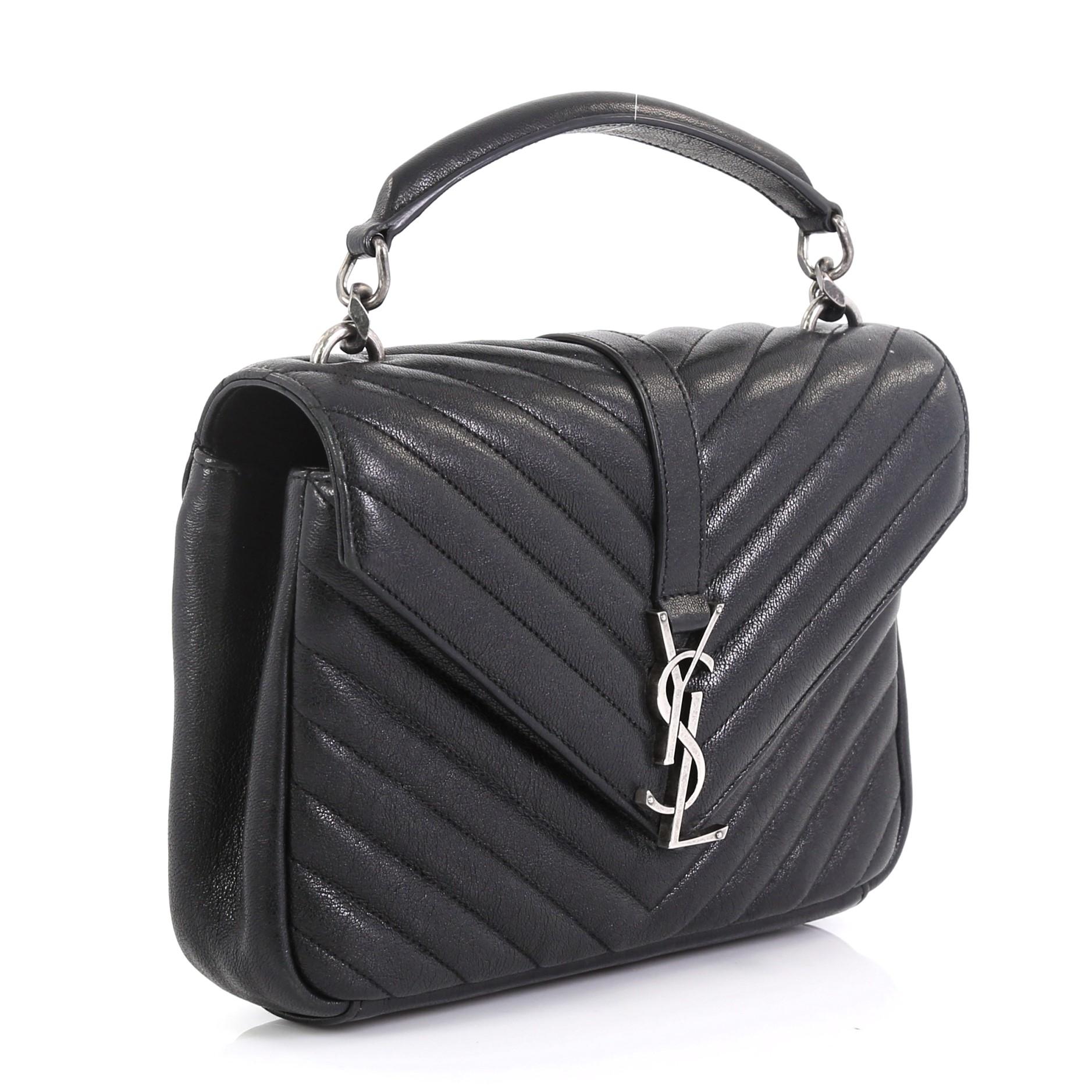 This Saint Laurent Classic Monogram College Bag Matelasse Chevron Leather Medium, crafted in black matelasse chevron leather, features a single top handle, exterior back pocket, and aged silver-tone hardware. Its magnetic snap closure opens to a