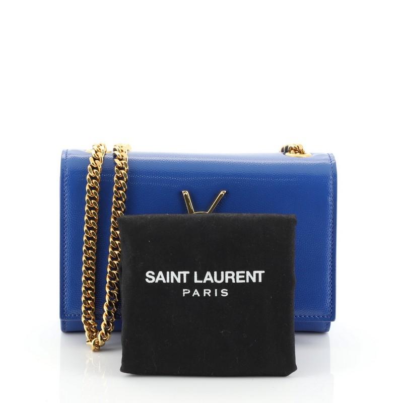 This Saint Laurent Classic Monogram Crossbody Bag Grainy Patent Small, crafted in blue grainy patent leather, features gourmette chain strap, interlocking YSL logo at its center, and gold-tone hardware. Its magnetic snap closure opens to a blue
