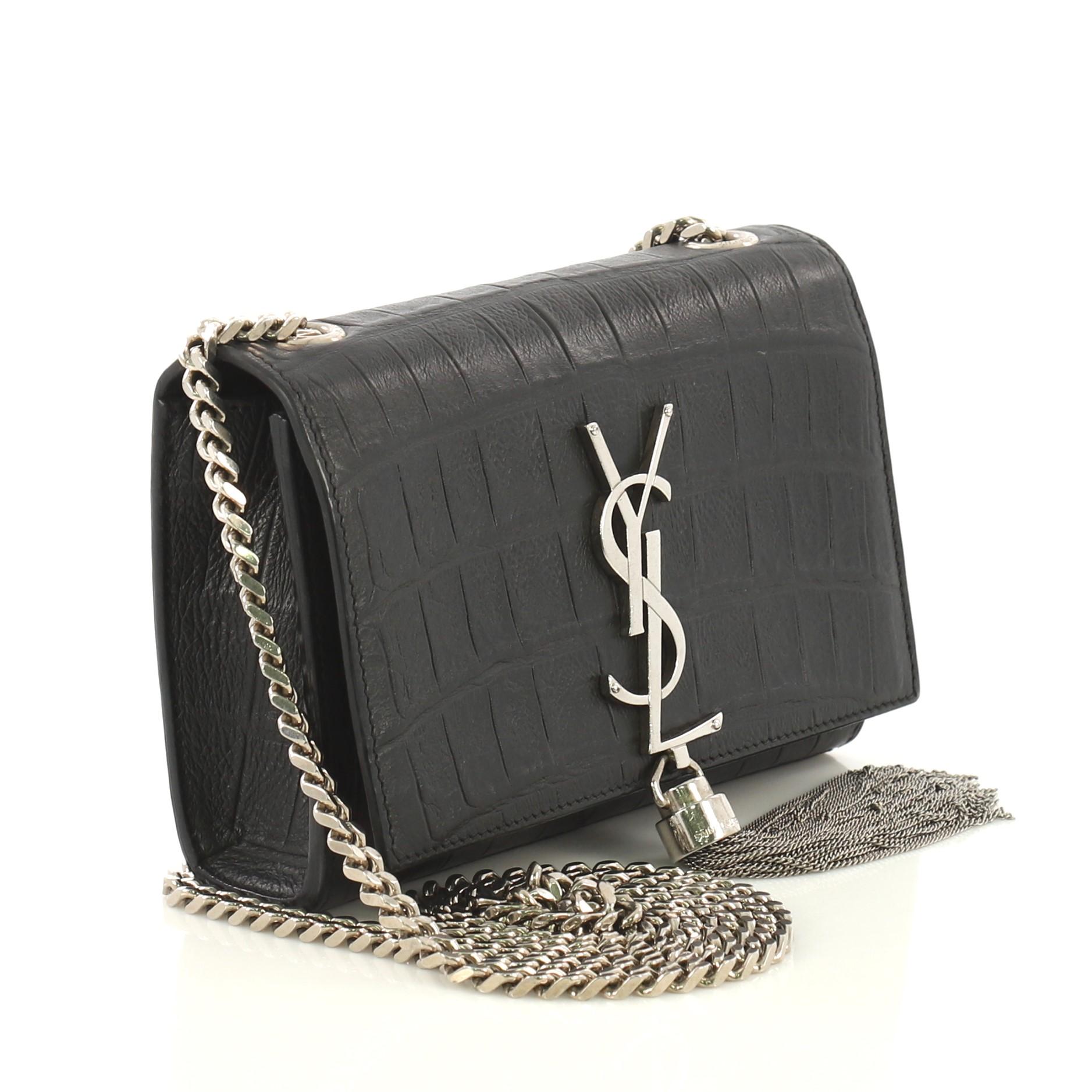 This Saint Laurent Classic Monogram Tassel Crossbody Bag Crocodile Embossed Leather Small, crafted from black crocodile embossed leather, features gourmette chain strap, interlocking YSL logo at its center with attached fringe tassel, and