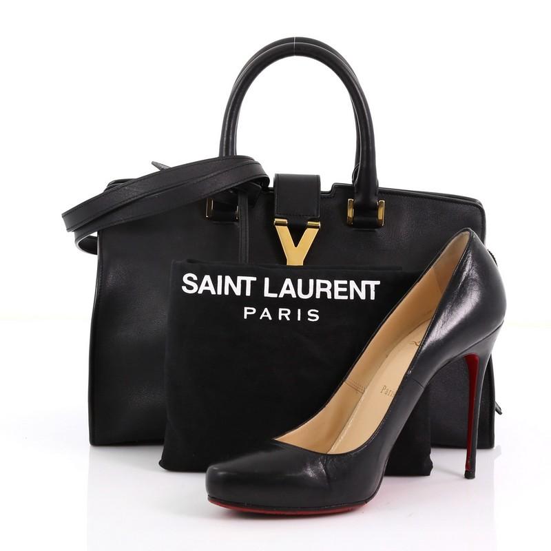 This Saint Laurent Classic Y Cabas Leather Small, crafted from black cabas leather, features dual rolled leather handles, signature Yves Saint Laurent's 'Y' top flap hardware piece, protective base studs, and gold-tone hardware. Its top zip closure