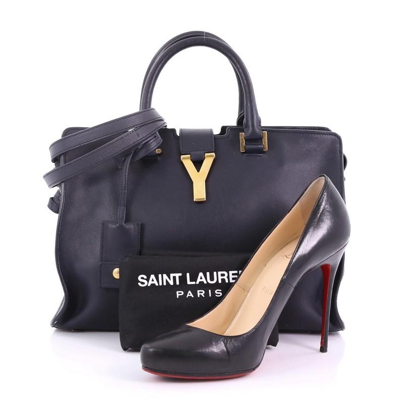 This Saint Laurent Classic Y Cabas Leather Small, crafted from navy leather, features dual rolled leather handles, signature Yves Saint Laurent's 'Y' top flap hardware piece, protective base studs, and gold-tone hardware. Its top zip closure opens