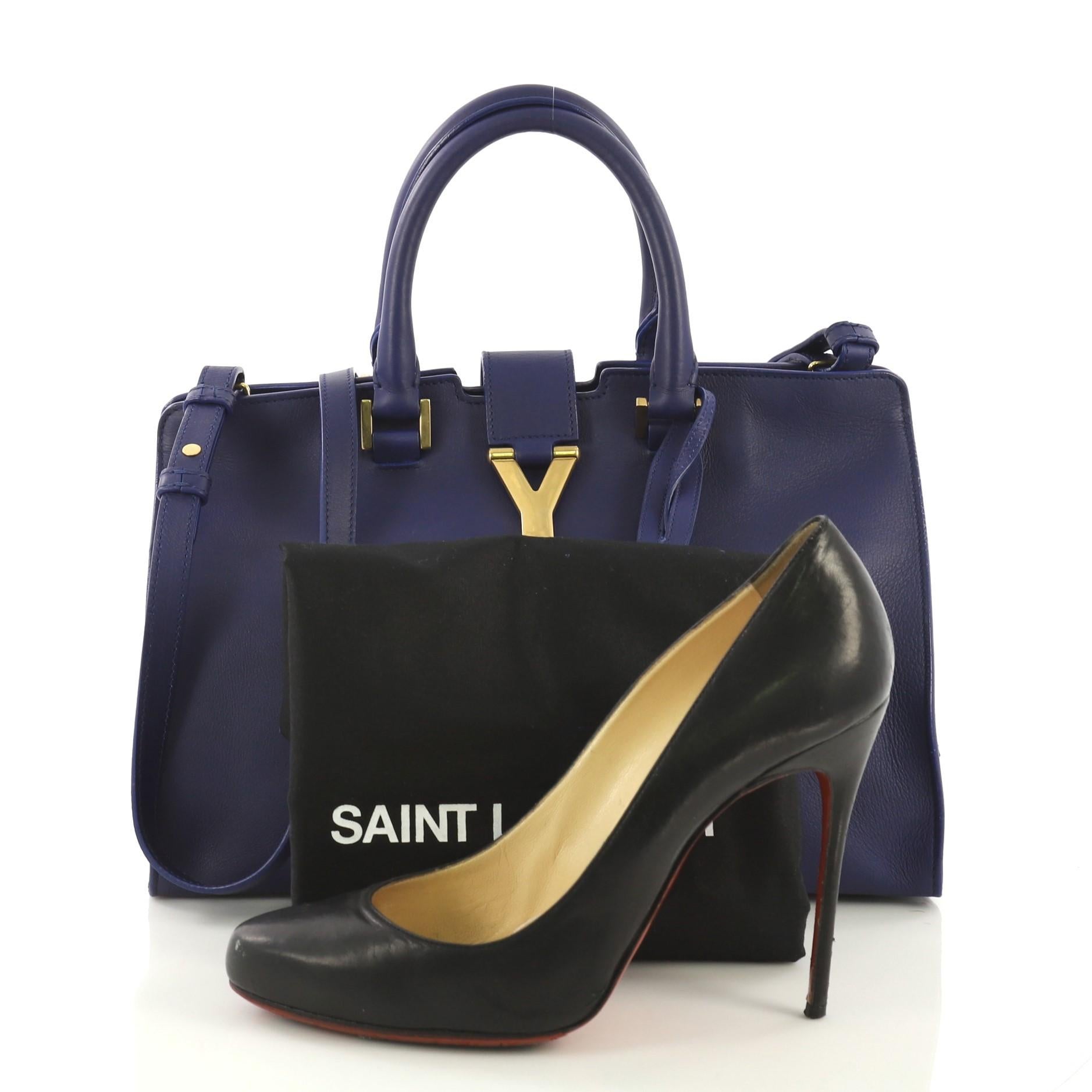 This Saint Laurent Classic Y Cabas Leather Small, crafted from blue leather, features dual rolled leather handles, signature Yves Saint Laurent's 'Y' top flap hardware piece, protective base studs, and gold-tone hardware. Its top zip closure opens