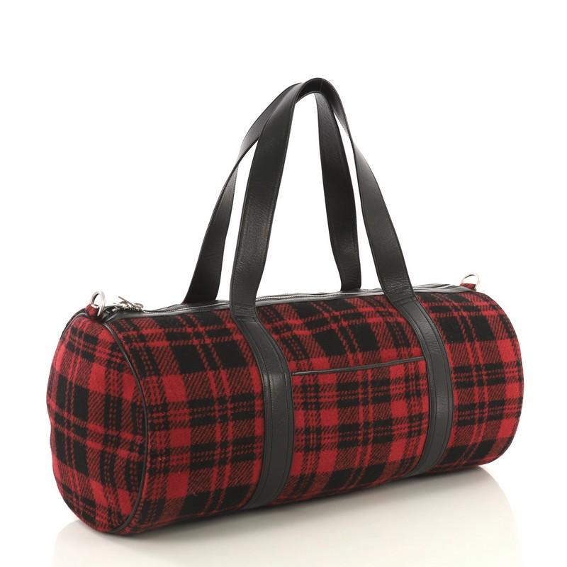 This Saint Laurent Convertible Weekender Bag Wool, crafted in red wool, features dual flat leather handles, exterior slip pocket, leather trim, and silver-tone hardware. Its zip closure opens to a black fabric interior with snap pocket.

Condition: