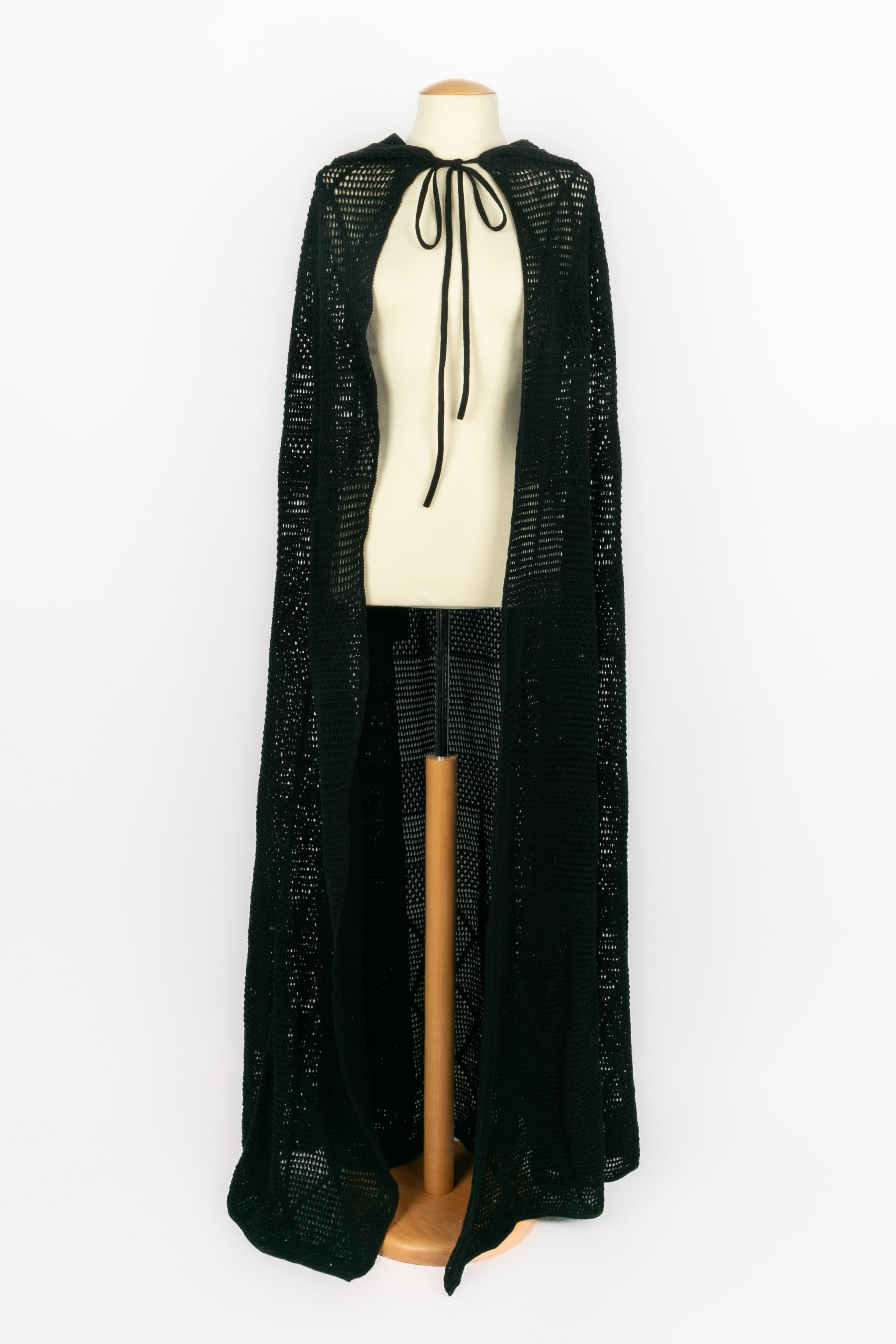 YVES SAINT LAURENT - Long hooded poncho cape made of black crochet with a trimming pompom. Composition and size labels missing, it fits a 38FR/40FR/42FR.

Condition:
Very good condition

Dimensions:
Shoulder width: 47 cm - Length: 150 cm

SKU:M150