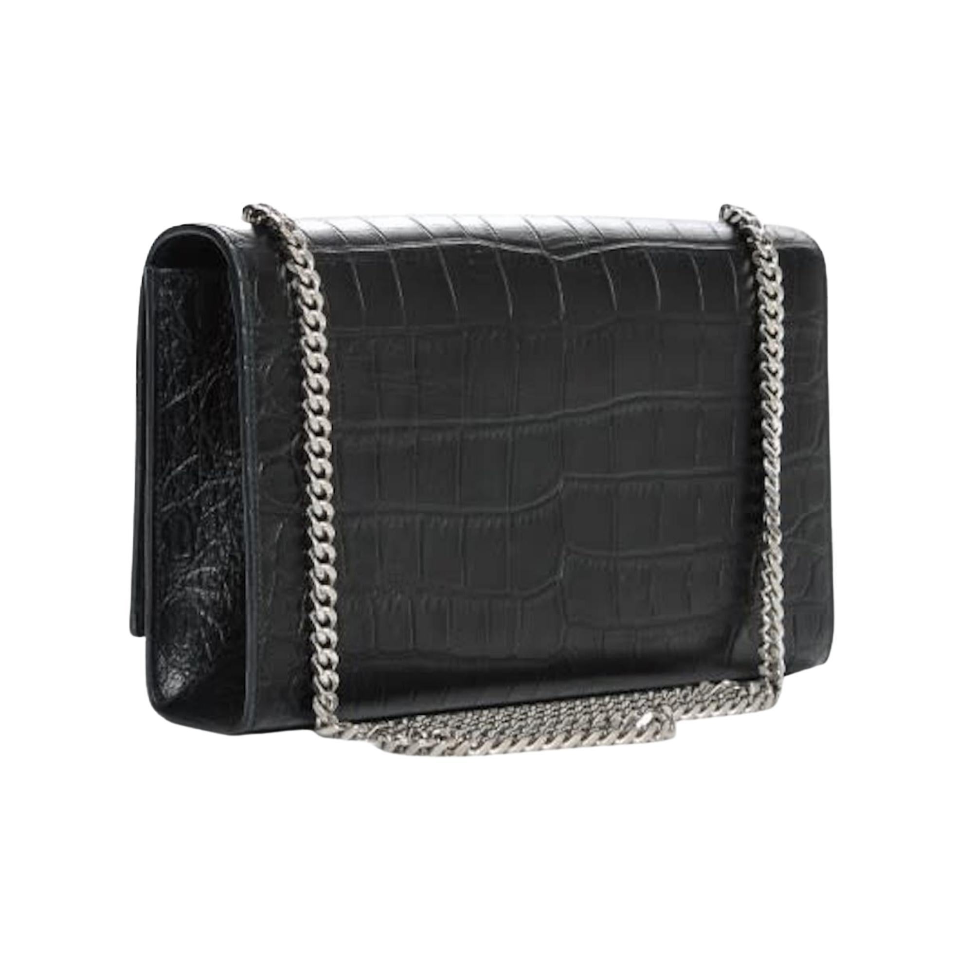 This shoulder is made of crocodile embossed calfskin in black and features an aged silver chain shoulder strap, a front flap, an aged silver YSL logo, a chain tassel and leather interior lining.

COLOR: Black
MATERIAL: Croc embossed calfskin
ITEM