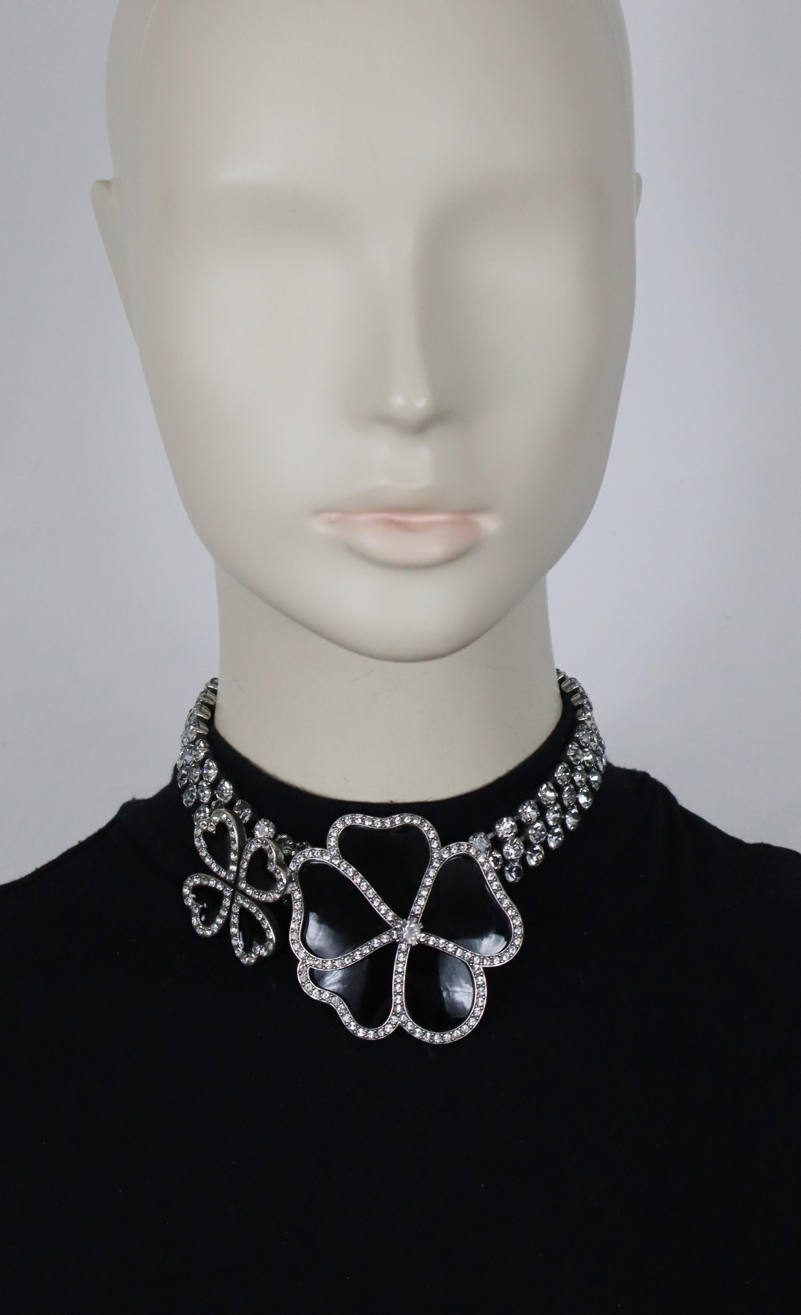 Collana girocollo SAINT LAURENT in tonalità argento anticato con catene di cristalli trasparenti, un fiore centrale in resina nera e un quadrifoglio impreziosito da cristalli trasparenti.

Chiusura a moschettone regolabile.

Goffrato SAINT LAURENT