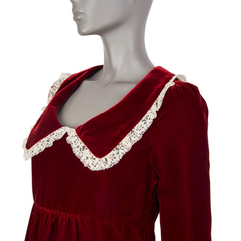 Saint Laurent long-sleeve velvet dress in deep red viscose (65%) and cupro (35%). With empire waist, lace-trimmed low flat collar and cuffs. Closes with invisible zipper on the side. Lined in black silk (100%). Has been worn and is in excellent