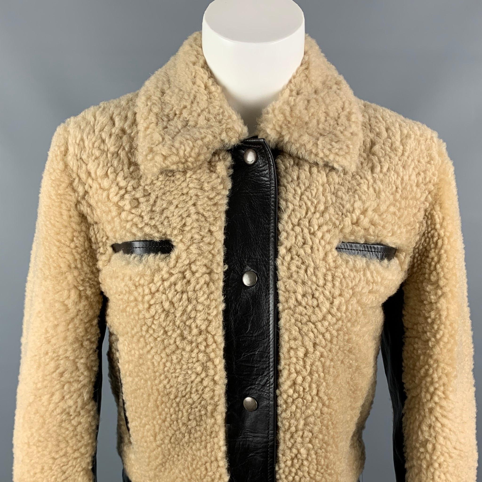 SAINT LAURENT Fall 21 short jacket comes in a tan shearling with a brown leather trim design featuring a wide pointed collar, snap button cuffs, four pockets, and a snap button closure. Made in Italy.

New Without Tags. 
Marked: F 34
Original Retail