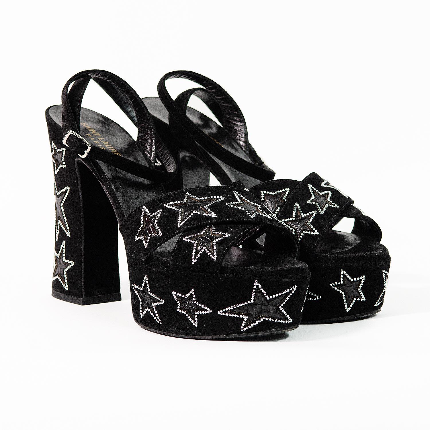 The most incredible 1970s inspired platform sandals by Saint Laurent with star embellishment. The model is Farrah. These rare platform sandals are the perfect statement shoe! 

These star studded platforms feature a block heel, an ankle strap with a