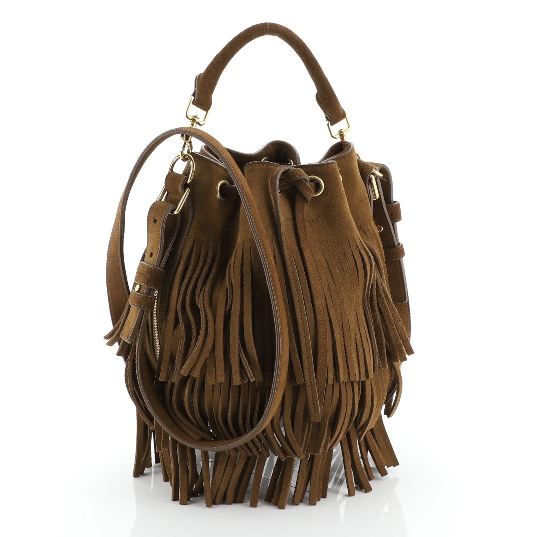 This Saint Laurent Fringe Emmanuelle Bucket Bag Suede Small, crafted in brown suede, features a detachable looped handle, adjustable suede strap, cascading, long brown suede fringes, side zip pockets and gold-tone hardware. Its drawstring closure