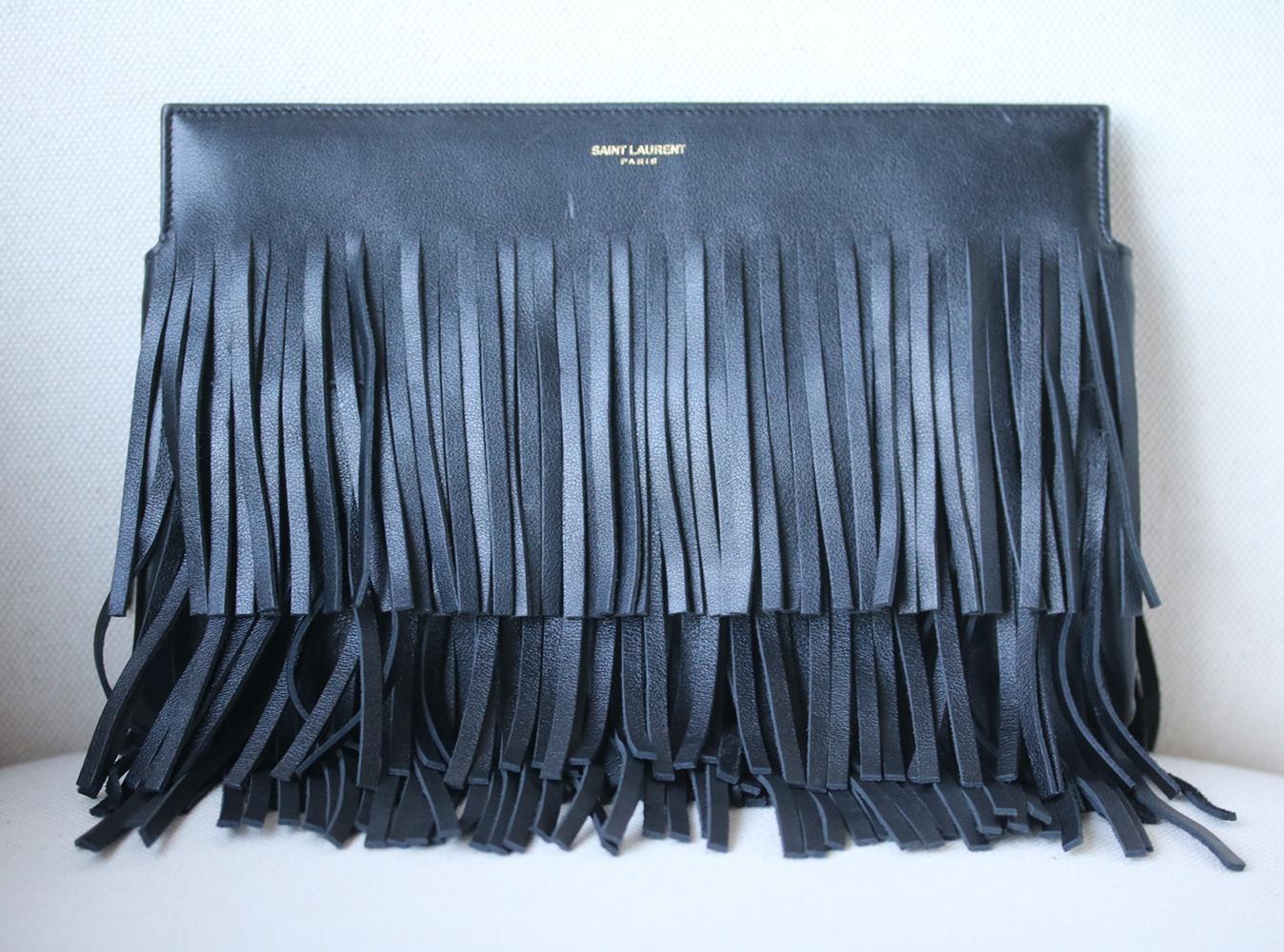 Saint Laurent nods to Western trends with this fringed black leather clutch. It's subtly embossed with gold designer lettering and features concealed magnetic fastenings for a clean, uncluttered look. Fill the faille-lined interior with all your