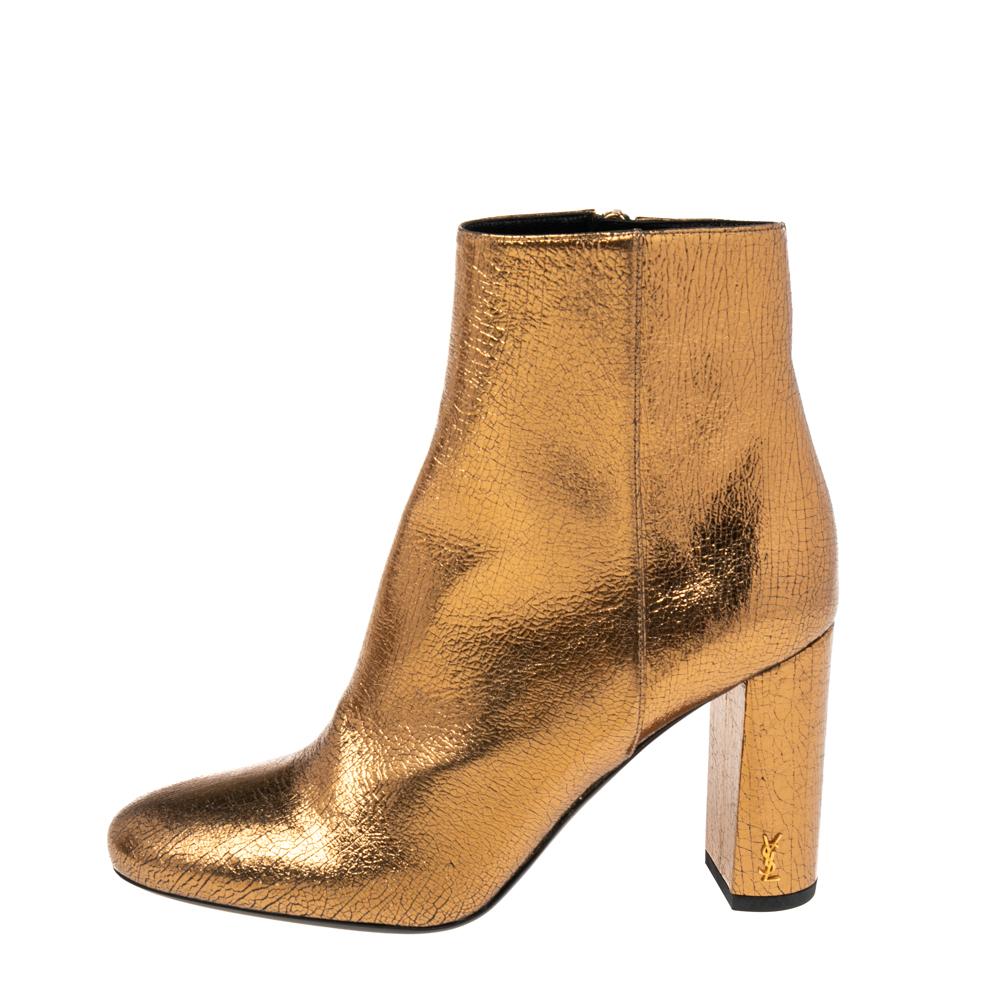 Add a hint of oomph to your look with these boots from Saint Laurent. They are made using gold leather on the exterior and are decorated with gold-toned hardware, block heels, and covered-toes. For closure, they are provided with zippers. These