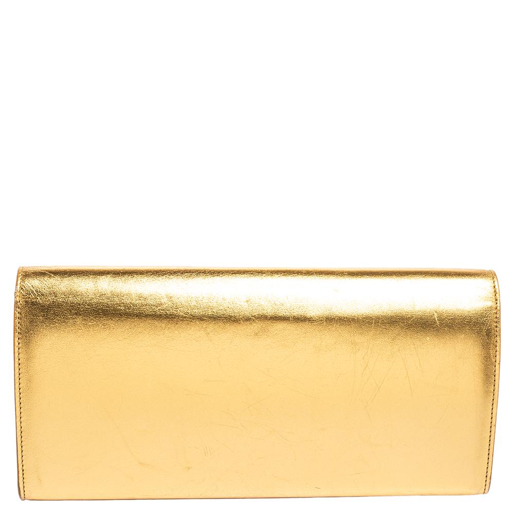 This exquisite Cassandre clutch from Saint Laurent is a chic accessory that represents the brand's rich aesthetics flawlessly. It is made from gold leather on the exterior and flaunts a gold-toned logo embellishment on the front. Fetch only praise