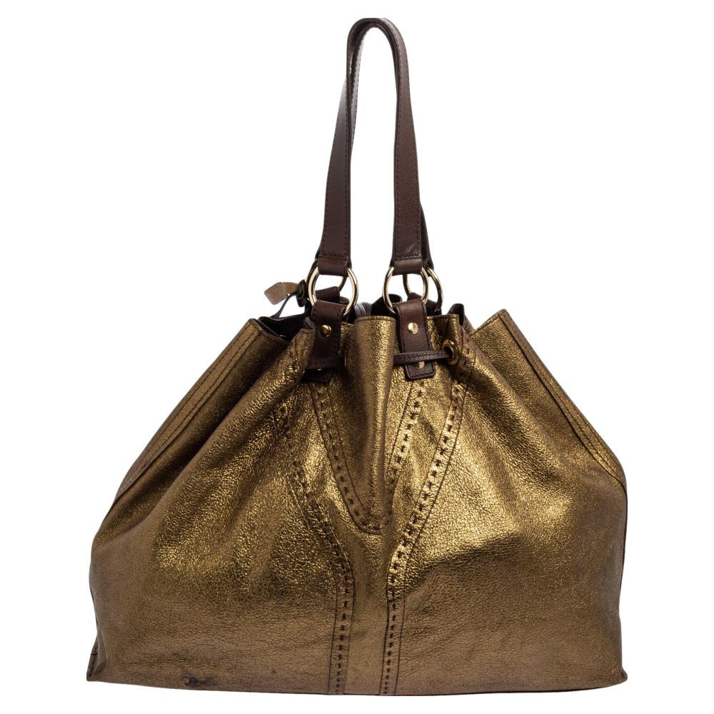 This Double Sac Y tote bag comes from Saint Laurent and it will definitely make your outfit more interesting! It is crafted in Italy from quality leather. It comes in lovely hues of gold. This large reversible tote is finished with a subtly stitched