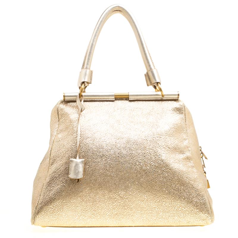 You can surely count on this lovely Majorelle tote by Saint Laurent Paris for an all-time statement look. Crafted from shimmery gold leather, it features a sleek structured design with two covered metal frame rods on the top. It features a YSL