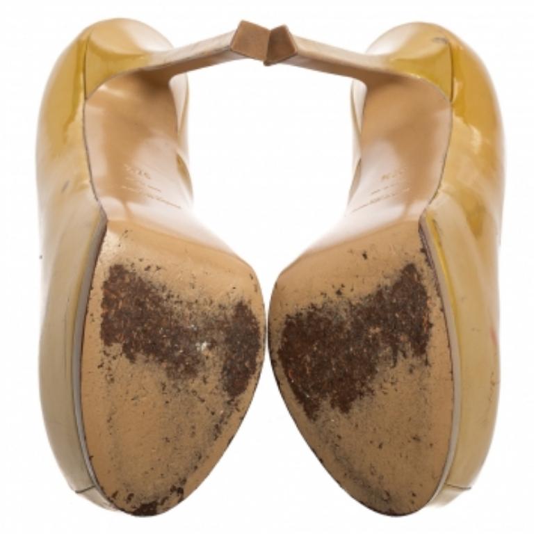 Ces exquis escarpins Tribtoo de la maison Saint Laurent sont parfaits pour afficher un style glamour. Elles sont fabriquées avec soin en cuir verni doré sur l'extérieur et sont ornées de bouts arrondis, de plates-formes et de magnifiques talons de