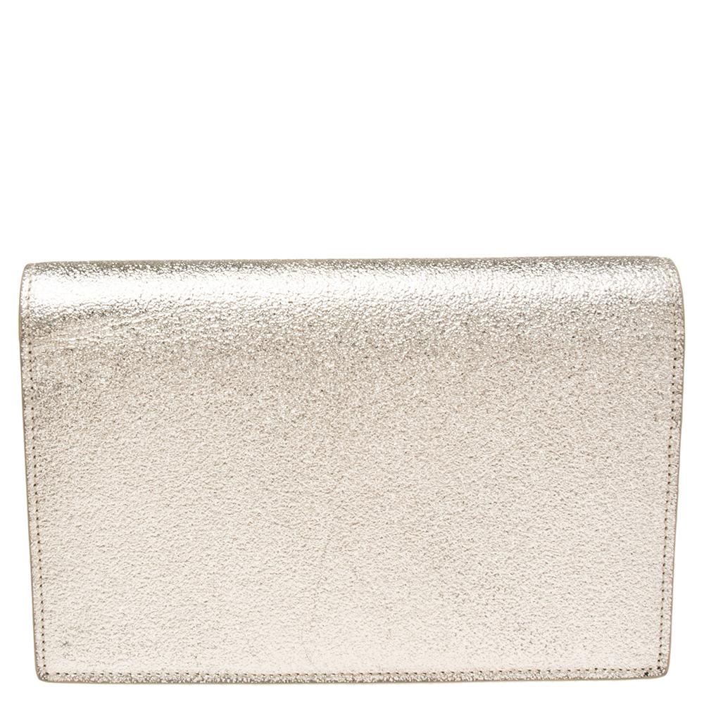 Elevate the look of your party outfits with this stunning wallet on chain from the house of Saint Laurent. It is fashioned in gold textured leather and is adorned with a gold-toned YSL logo as well as a tassel on the front. It has a leather-lined
