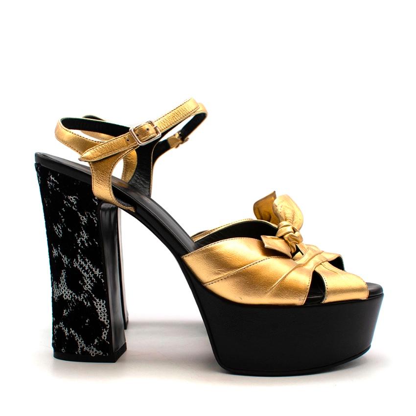 Saint Laurent Golden Leather & Sequins Platform Sandals 

-Made of soft leather 
-Beautiful golden hue 
-Gorgeous velvet and sequins detail to the heels
-Bow detail to the toes
-Soft leather lining 
-Chunky heel for stability 
-Fun luxurious design