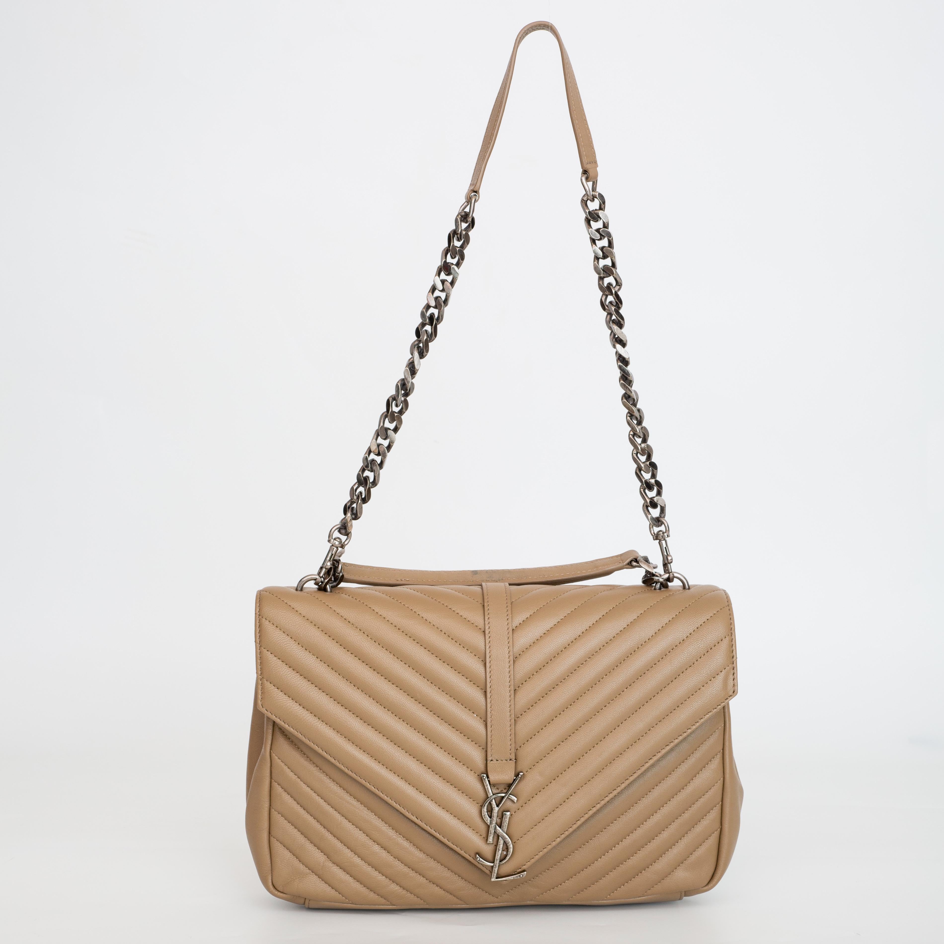 This tote features chevron quilting in beige. The shoulder straps feature leather shoulder pads and polished brass-tone chains. The front features an aged sliver YSL monogram strap and opens to a black fabric interior with a zip pocket.

COLOR: