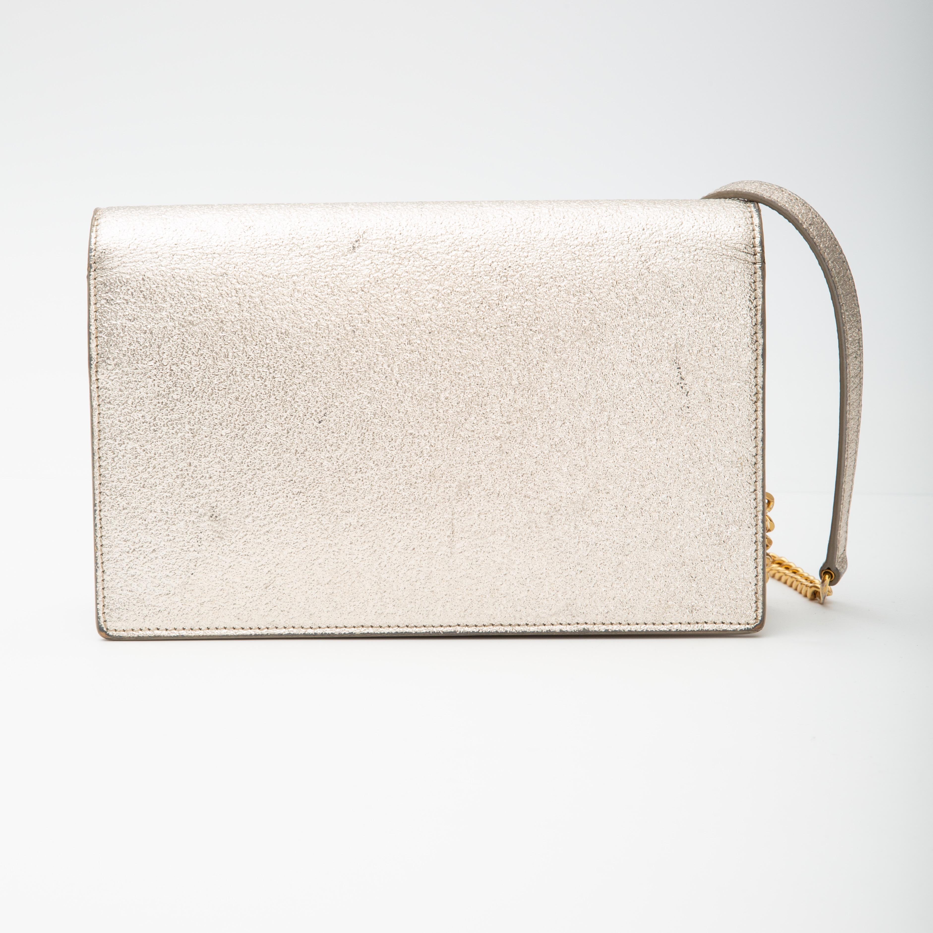 Ce sac à bandoulière Kate en or clair de Saint Laurent est confectionné en cuir de veau grainé en or. Ce modèle présente les initiales YSL en métal doré, une pampille en chaîne, une fermeture à pression magnétique, une bandoulière en chaîne dorée et