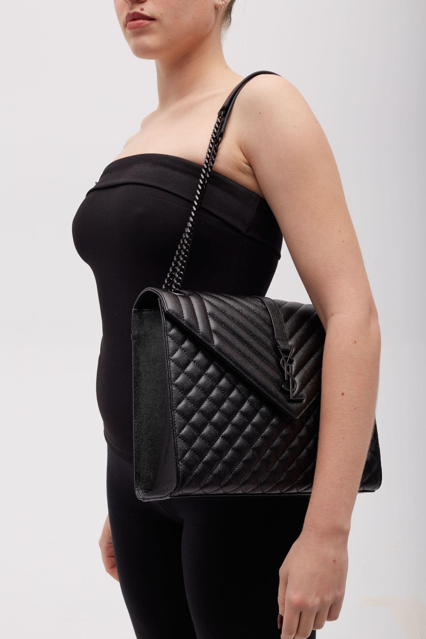 This shoulder bag is made of grained leather in black with matelasse chevron calfskin leather with linear and diamond quilting. The bag features a large exterior flat pocket, polished black chain link shoulder straps with leather shoulder pads and