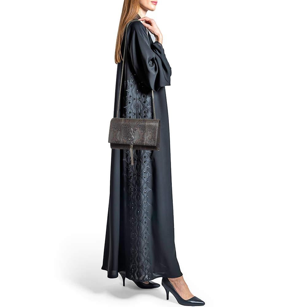 Diese sorgfältig aus Karung-Leder gefertigte Saint Laurent Kate Tasche strahlt genau die richtige Portion Raffinesse aus. Die Tasche verfügt über eine robuste silberfarbene Schulterkette, das YSL-Logo mit einer Quaste auf der vorderen Klappe und ein