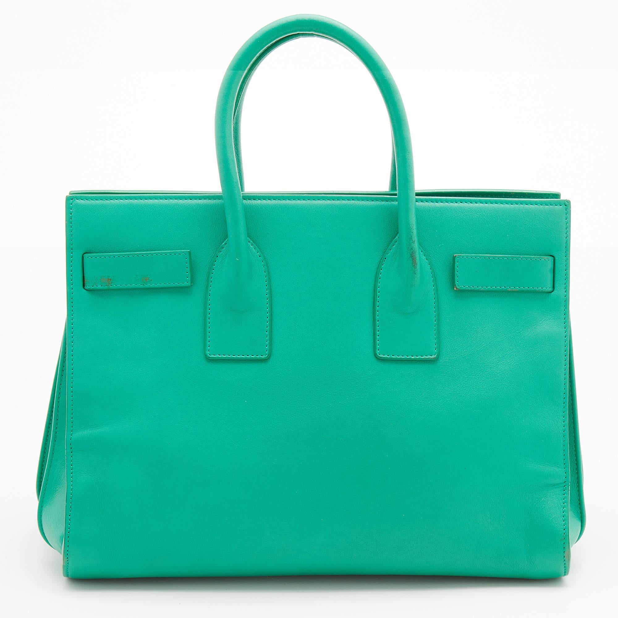 Made in a green shade, this Saint Laurent Sac De Jour tote has a refined look. It comes made from leather and is lined with suede. The top handles, strap, and spacious interior enhance the design.

Includes: Detachable Strap, Padlock and Keys

