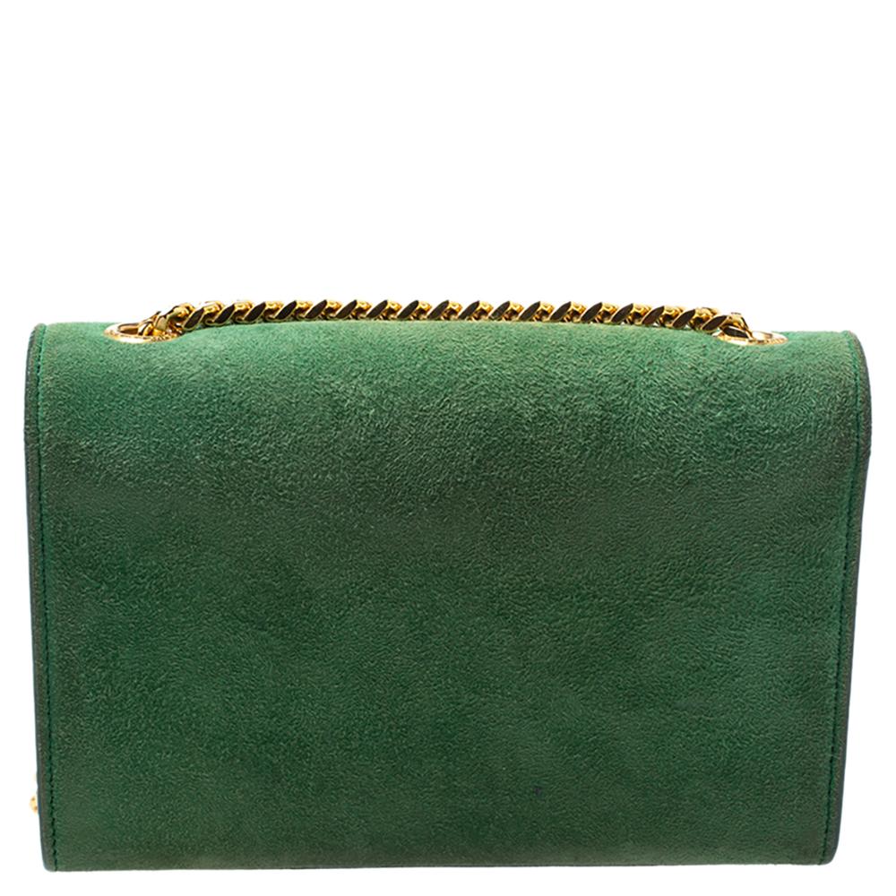 Meticulously crafted from green suede, this Saint Laurent Kate bag exudes just the right amount of sophistication. The bag features a sturdy gold-tone shoulder chain, the YSL logo with a tassel on the front flap and a canvas-lined compartment to