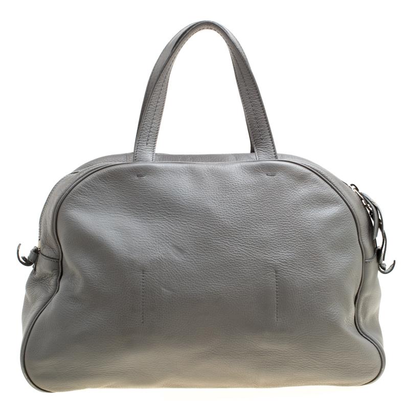 Step out like a celebrity with this stunning Obi bowler bag from the 2009 Spring/Summer collection by Saint Laurent Paris. The bag couples the label's iconic bow heritage with a bowler style. This grey bag has been beautifully crafted in pebbled