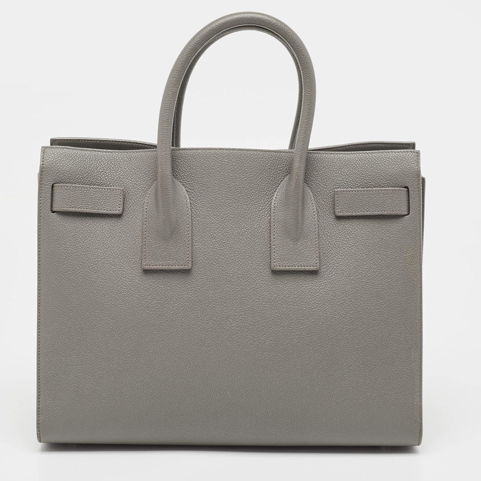Striking a beautiful balance between essentiality and opulence, this tote from the House of Saint Laurent ensures that your handbag requirements are taken care of. It is equipped with practical features for all-day ease.

Includes: Info Booklet,