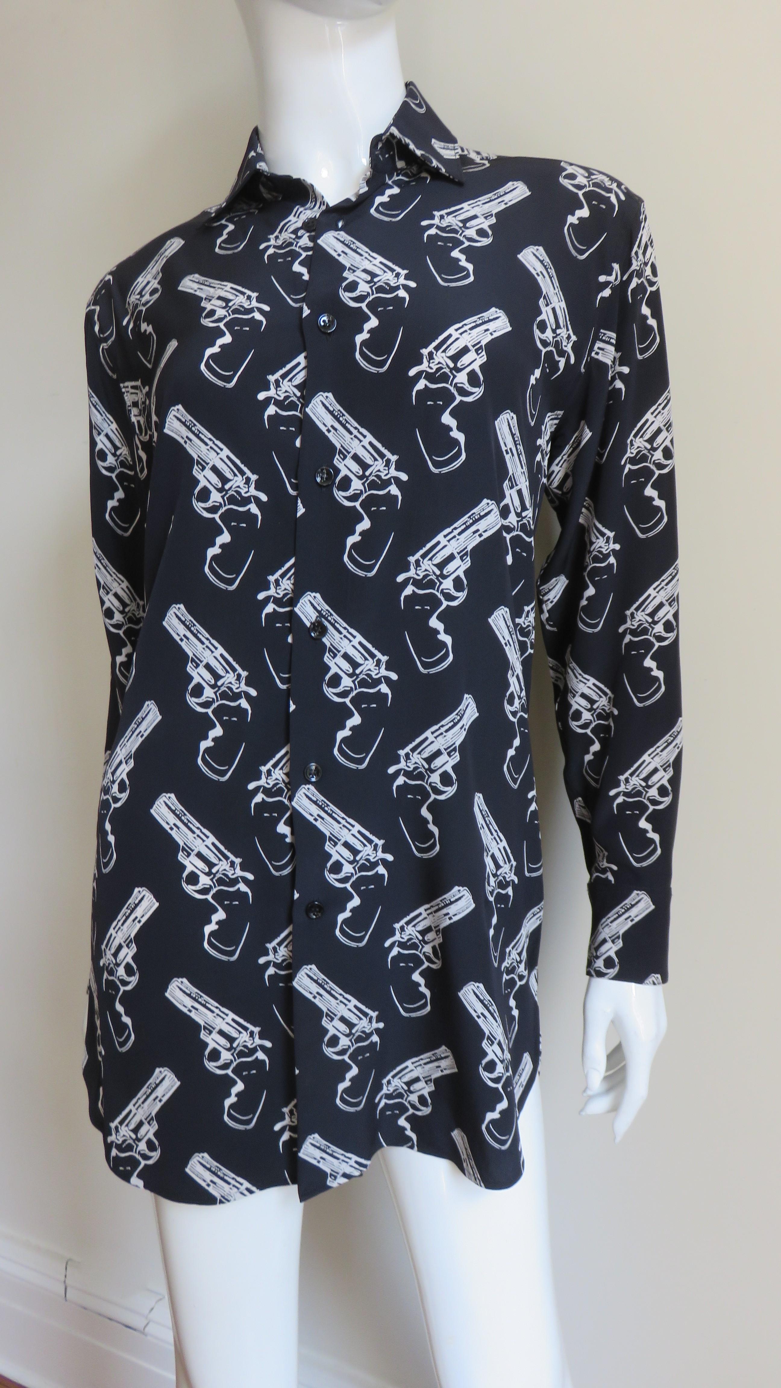 Una favolosa camicia di seta nera con stampa revolver in beige di Saint Laurent. Ha un colletto da camicia, orlo a coda di camicia, polsini con bottoni e chiusura frontale con bottoni neri.
Si adatta alle taglie Extra Small, Small, Medium. Marcato