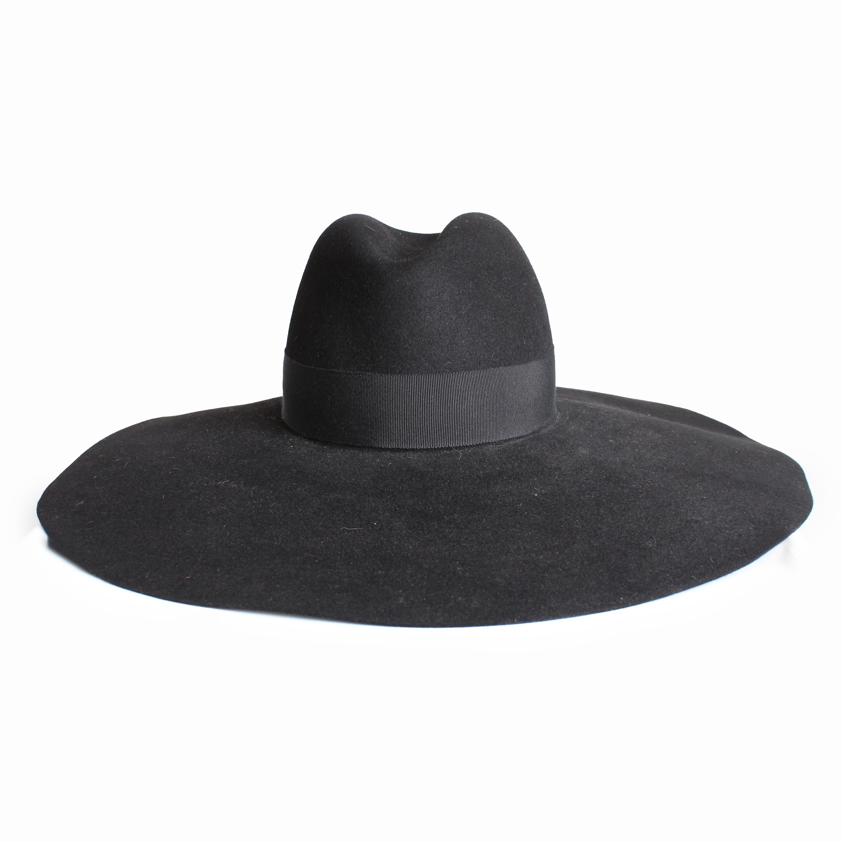 Schwarzer Hut mit breiter Krempe aus zweiter Hand, entworfen von Hedi Slimane für seine erste Laufstegkollektion bei Saint Laurent im Jahr 2012.  Dieser Hut aus schwarzem Kaninchenpelzfilz hat eine tropfenförmige Krone, die mit schwarzem Ripsband