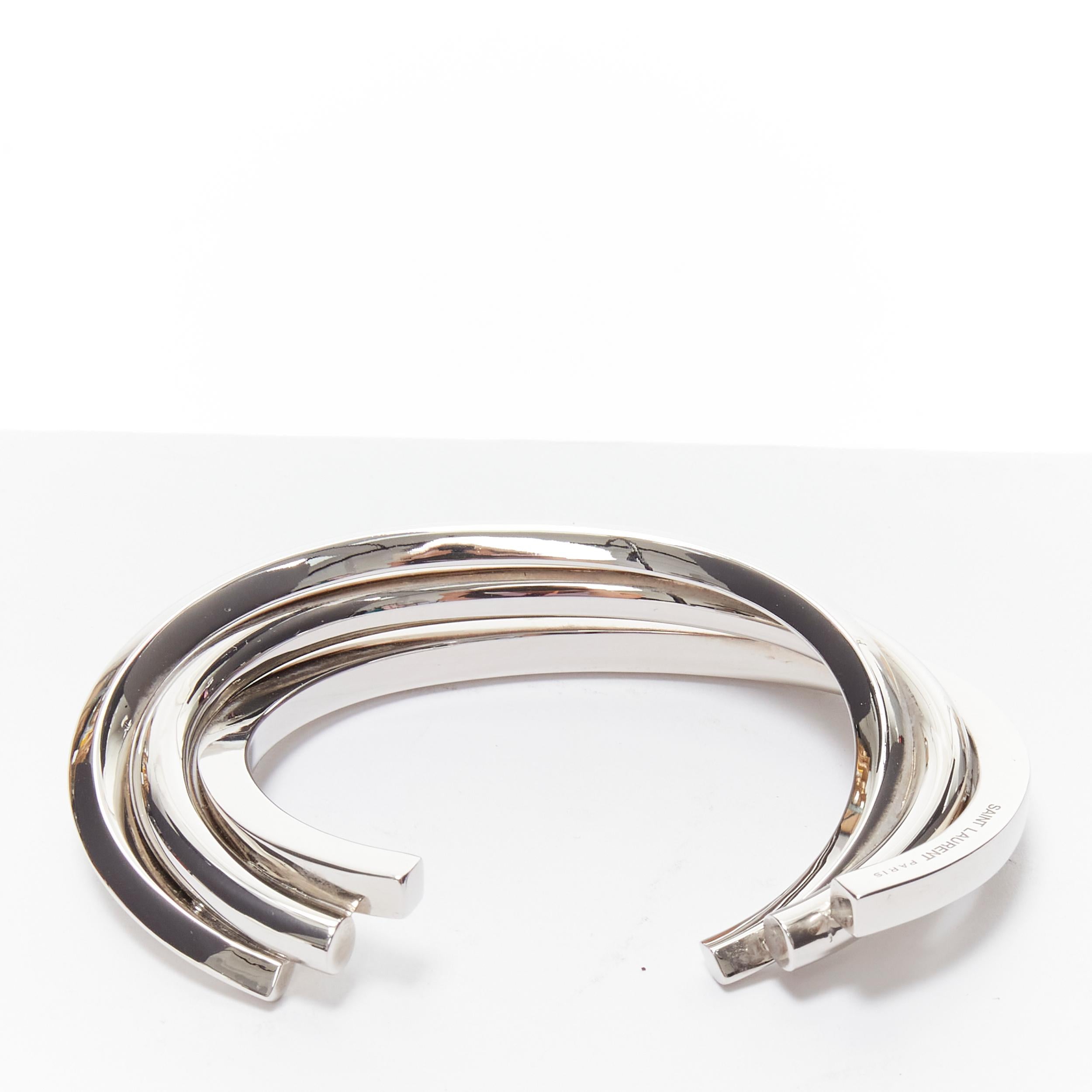 SAINT LAURENT Hedi Slimane silver brass architectural triple twist cuff bracelet 
Reference: TGAS/B01759 
Brand: Saint Laurent 
Designer: Hedi Slimane 
Material: Brass 
Color: Silver 
Pattern: Solid 
Extra Detail: Hedi Slimane for Saint Laurent.