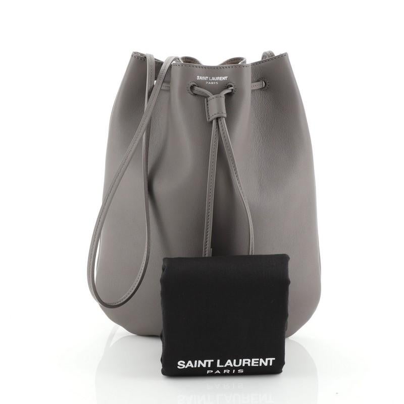 This Saint Laurent Jen Flat Bag Leather Small, crafted from gray leather, features long leather strap and aged silver-tone hardware. Its drawstring closure opens to a gray suede interior. T

Estimated Retail Price: $890
Condition: Very good. Slight
