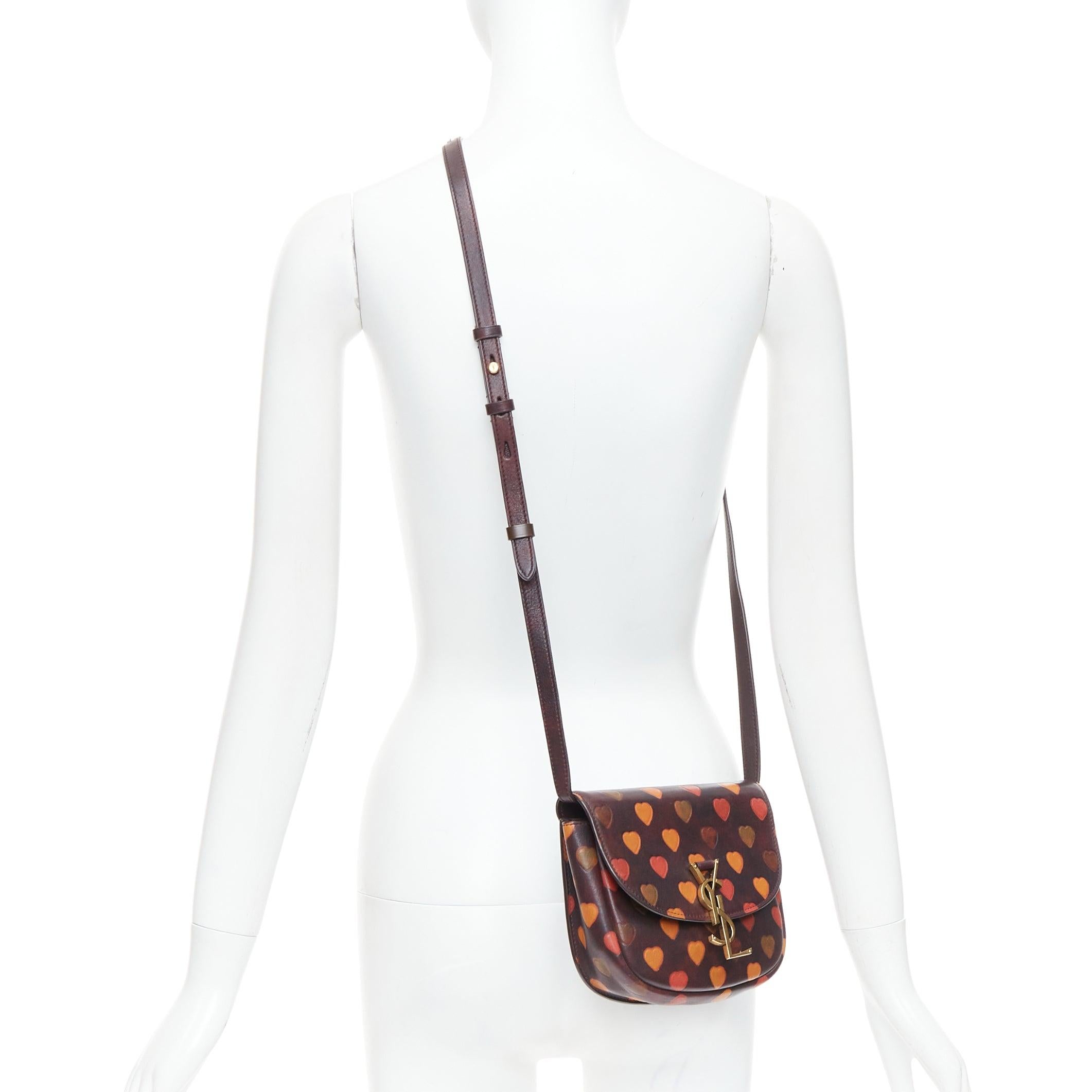 SAINT LAURENT Kaia brown heart embossed print YSL crossbody bag
Reference: TGAS/E00792
Brand: Saint Laurent
Designer: Hedi Slimane
Model: Kaia
Collection: 2021
Material: Leather
Color: Brown, Red
Pattern: Heart
Closure: Magnet
Lining: Brown