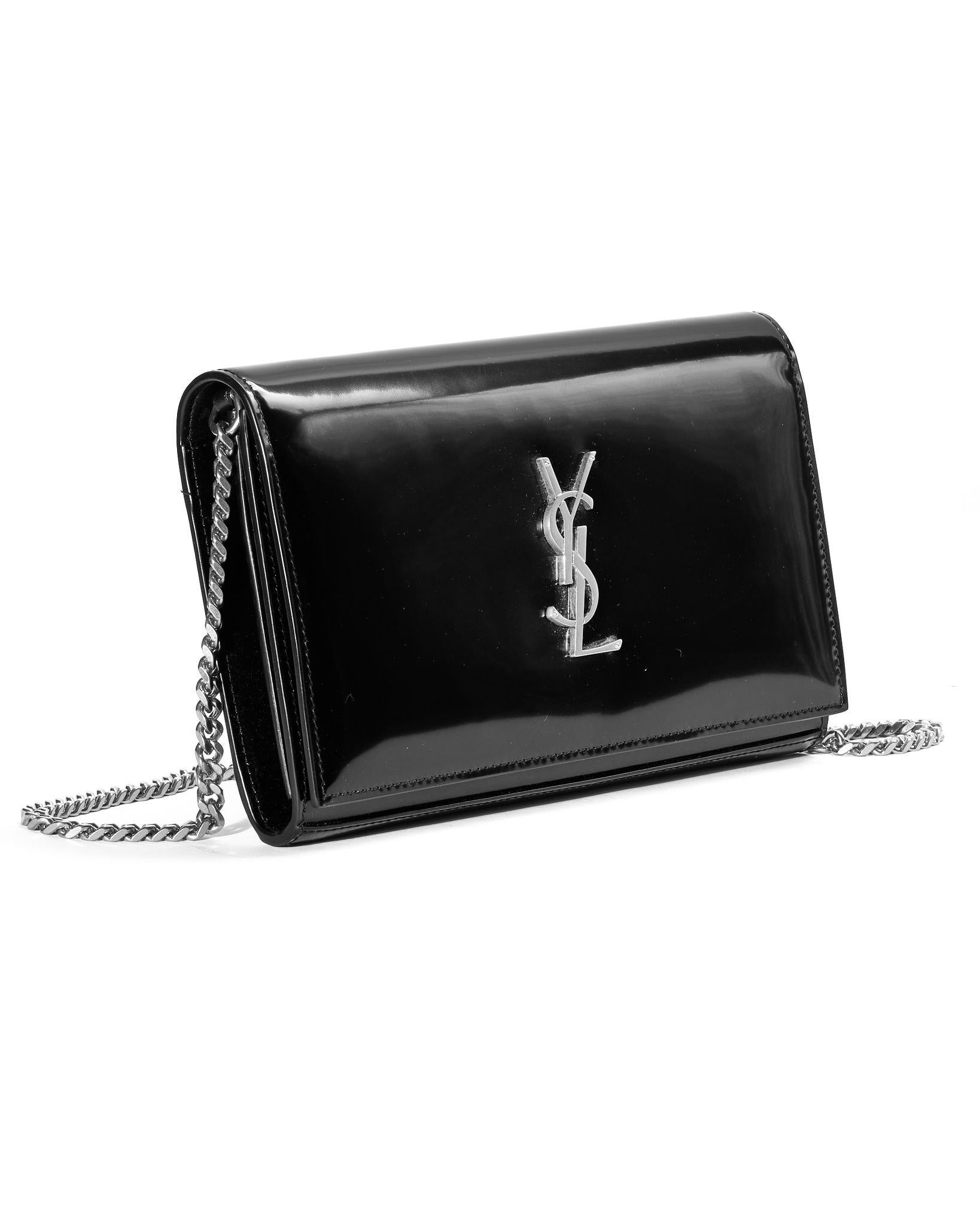Saint Laurent signature bag, model Kate in medium size, made of black patent leather with silver hardware details. The front flap is embellished with the classic silver metal 