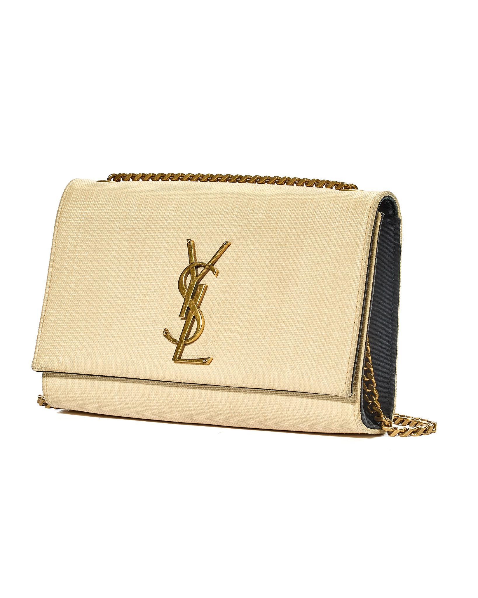 Borsa firmata Saint Laurent, modello Kate, realizzata in rafia beige con dettagli neri e rifiniture in hardware dorato. La patta frontale è decorata con il classico logo ‘YSL’ in metallo oro, accompagnato da una chiusura a bottone magnetico.