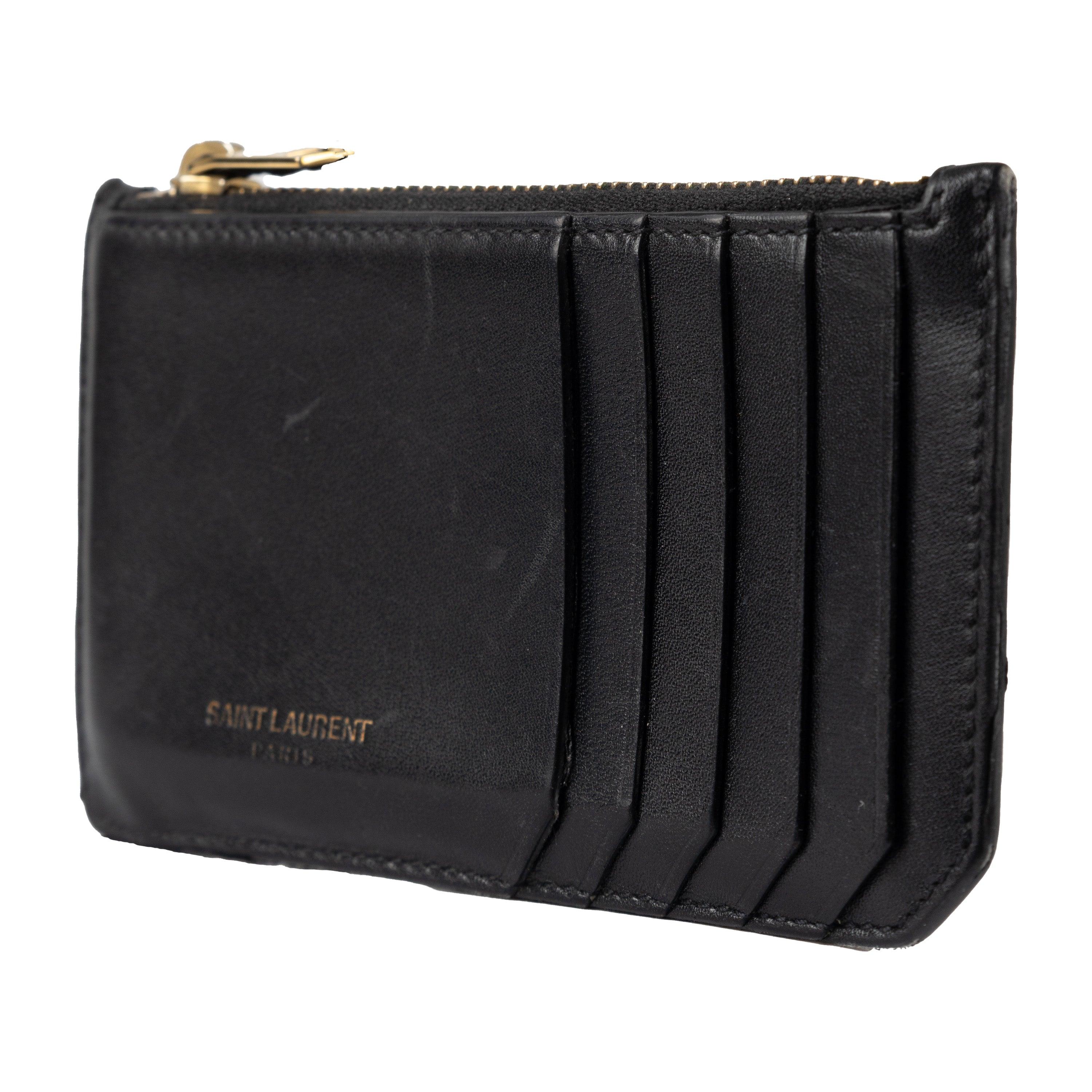 This Saint Laurent Leather Card Holder is crafted from smooth calf leather with a signature logo stamp. Its sleek design features a top zip fastening and multiple card slots, plus, a ridge on the side for added style. Perfect for your daily