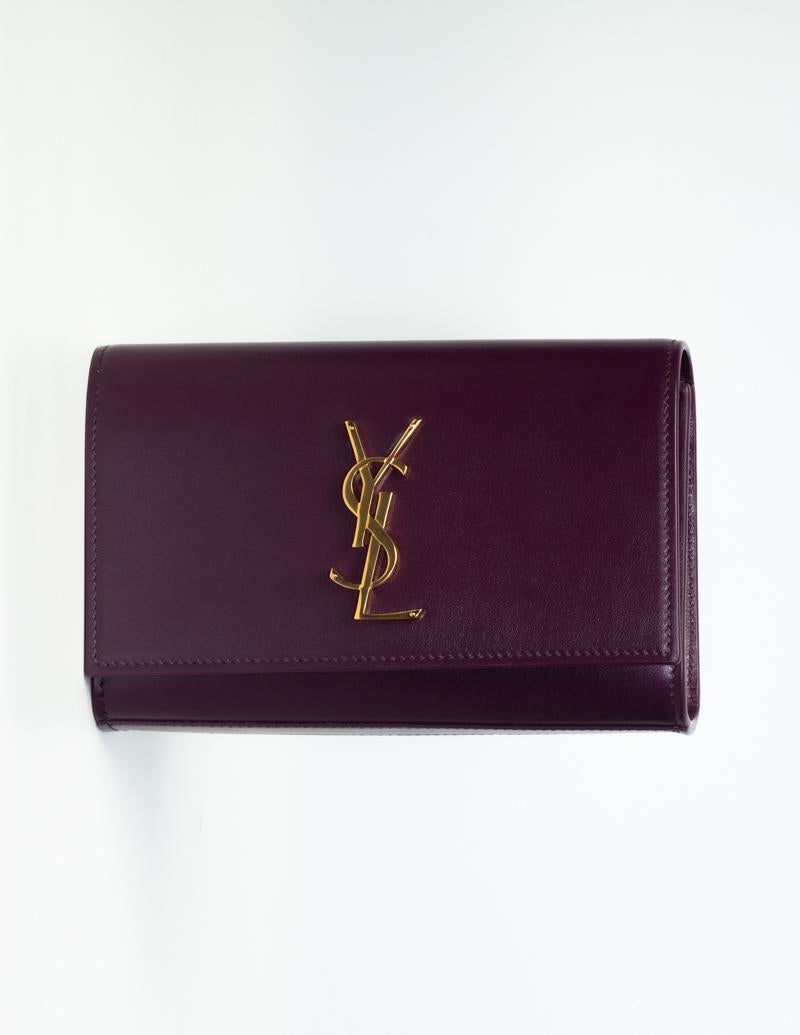 YSL Vitello Piumotto Prunia Kate Belt Bag Purple…This belt bag is made of smooth calfskin leather in purple. It features an adjustable belt strap, gold-toned hardware, a front flap with interlacing YSL logo, snap closure at flap and a compact black