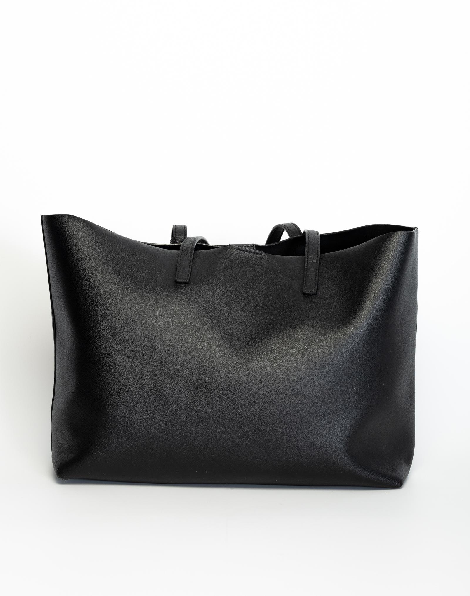 Questa tote è realizzata in pelle di vitello granulata di colore nero. Caratterizzata da doppio manico nella parte superiore, charm con logo inguainato su cordino staccabile alla base del manico, logo in tonalità oro nella parte anteriore, chiusura