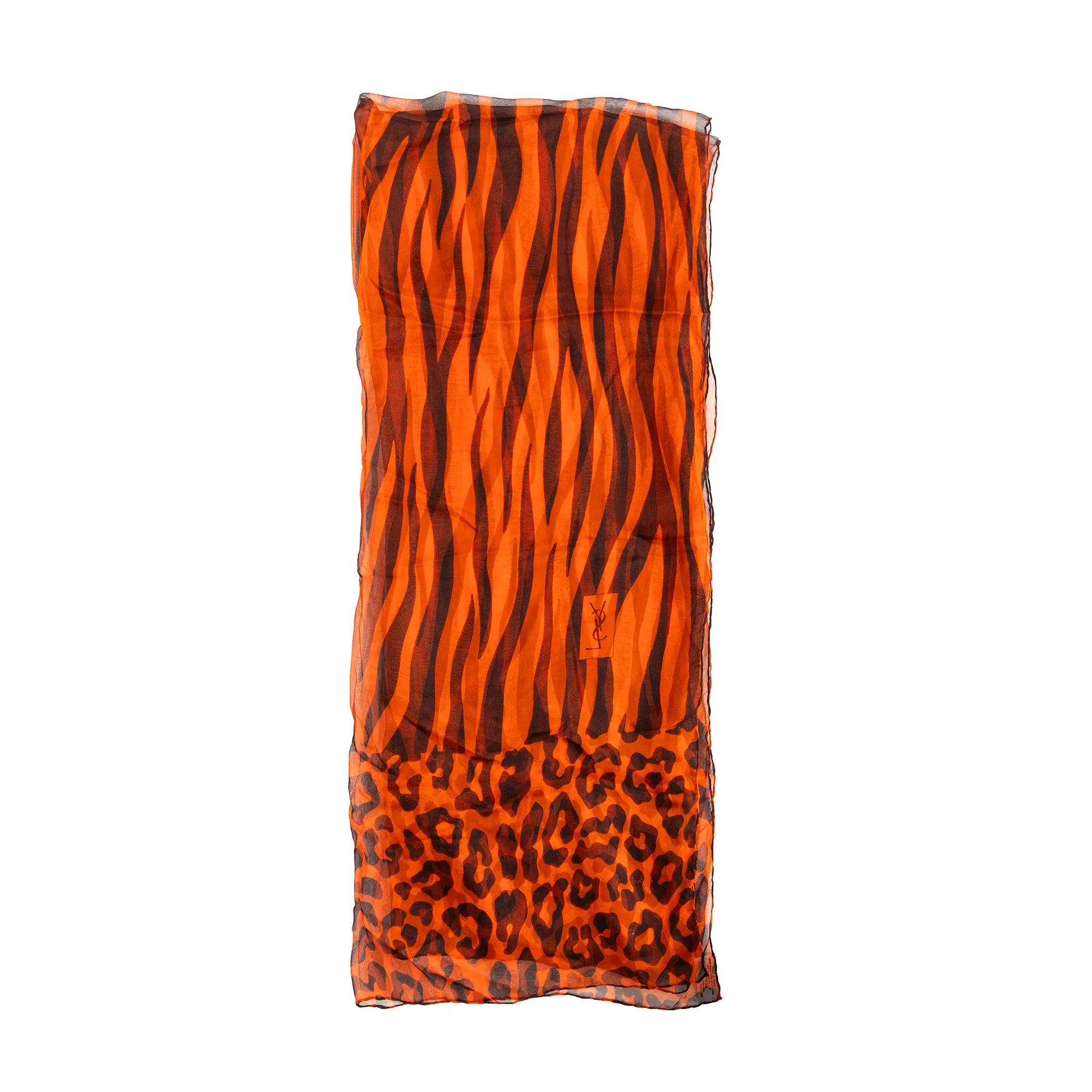 Vintage Yves Saint Laurent hand‑printed silk scarf featuring bold leopard motif in vibrant orange and brown tones. Made of 100% silk.
 Inclusion: envelope-style folder. 
 Material: 100% Silk 
 Measurements: Length:158;Width:66