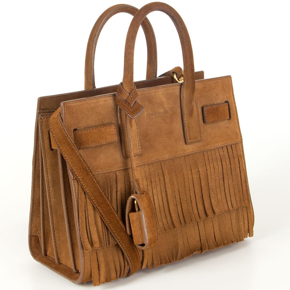 Saint Laurent Sac De Jour Nano Fringe shoulder bag in toffee brown suede. Lined in black calfskin with one open pocket against the back. Comes with a detachable and adjustable shoulder strap, lock and keys. Has been carried with some some soft marks